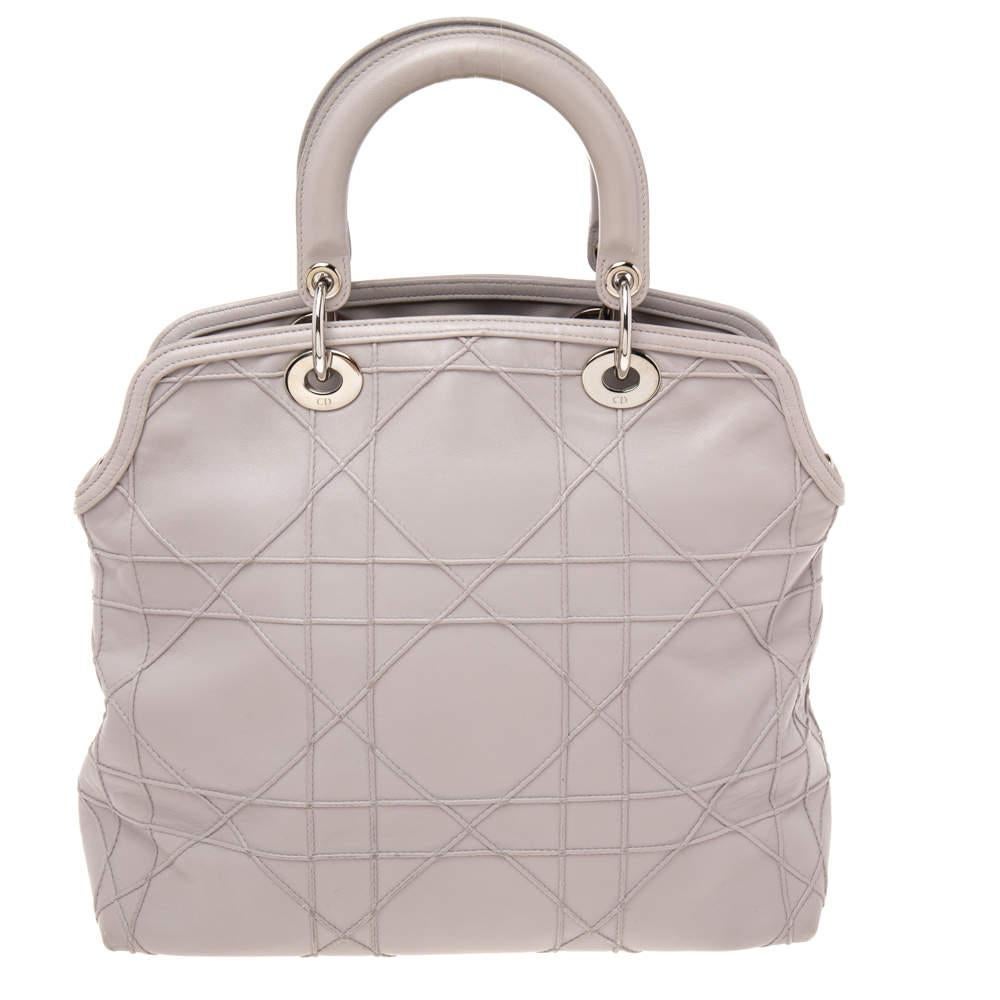 Presented by the House of Dior, this stunning Granville tote is a true statement accessory. It is crafted using pale lilac Cannage leather, with signature D.i.o.r. charms perched on the front. This tote provides two handles, silver-tone hardware,