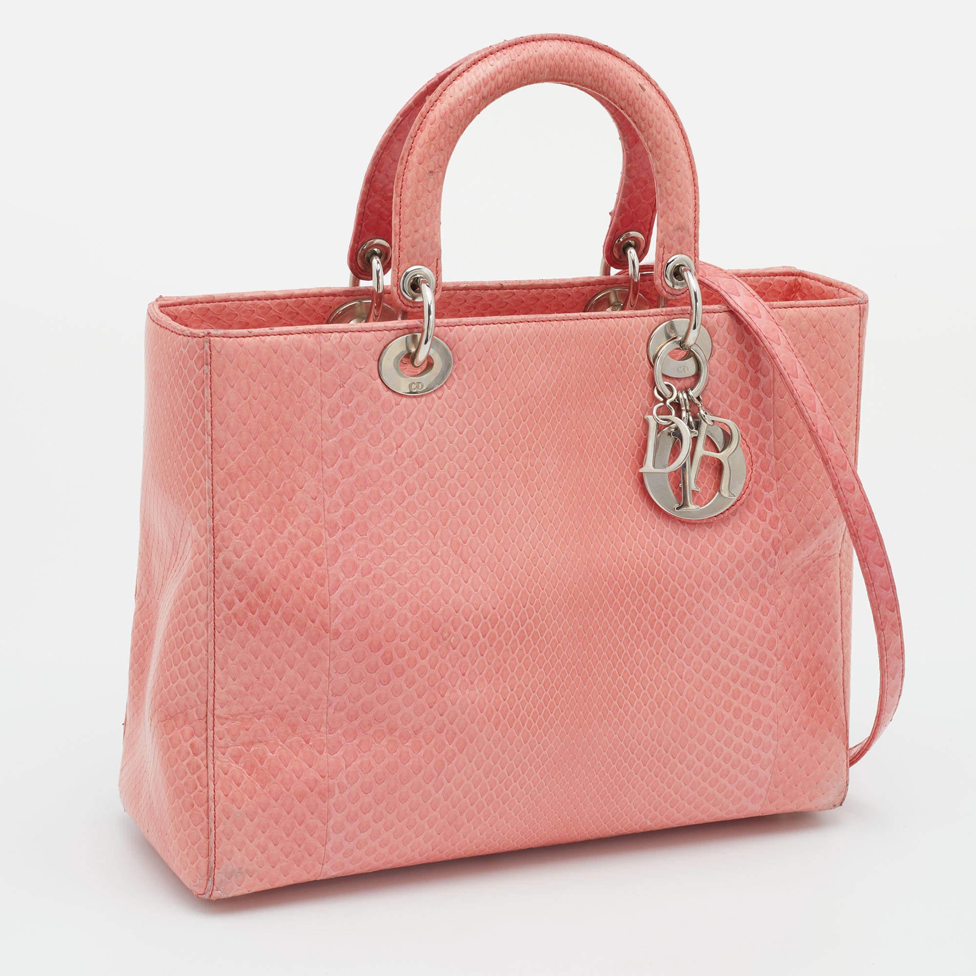 Ein zeitloser Status und ein großartiges Design kennzeichnen die Lady Dior-Tasche. Es ist eine ikonische Tasche, in die die Menschen bis heute investieren. Wir haben hier diese klassische Schönheit aus pfirsichfarbenem Pythonleder. Die Tasche hat