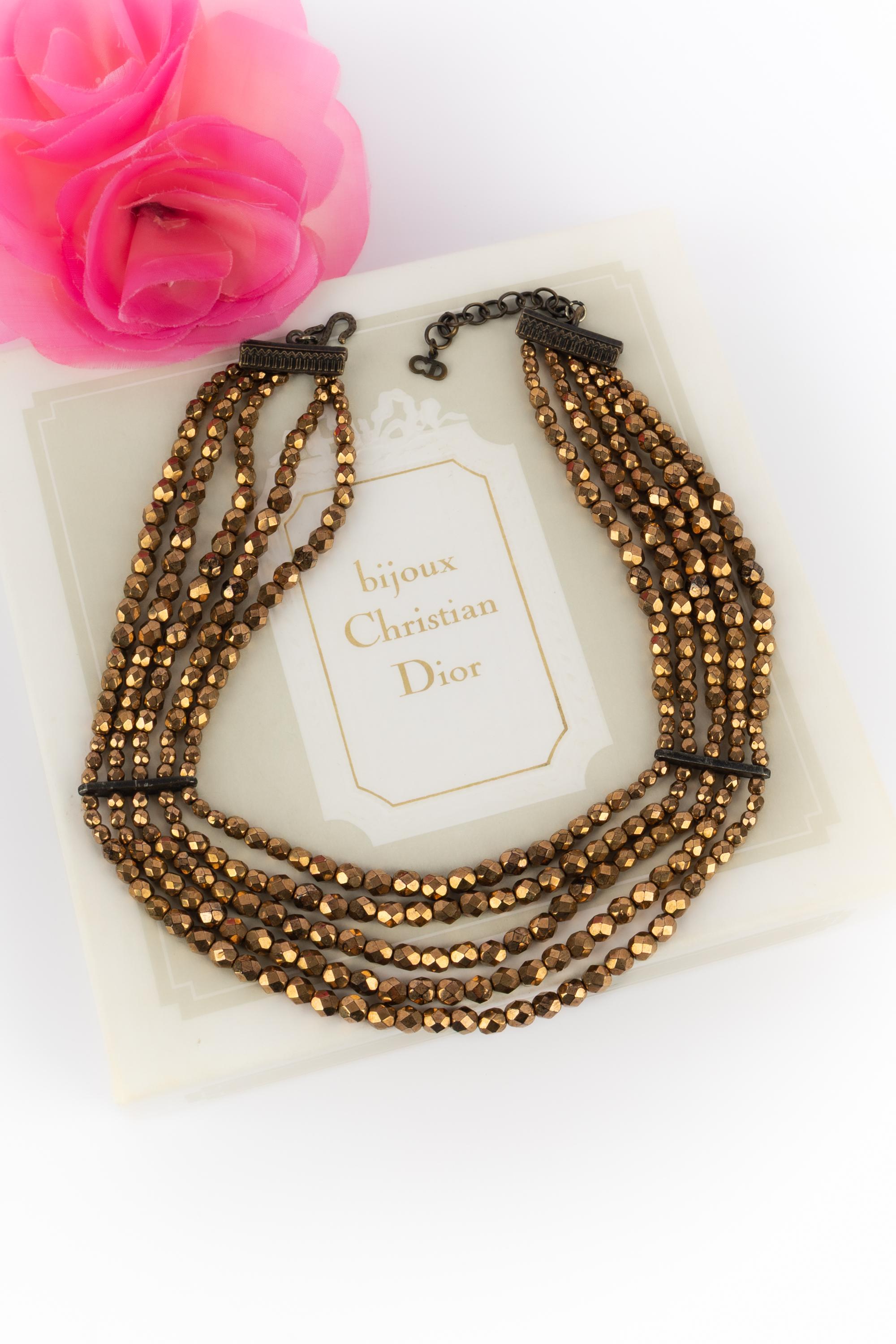 DIOR - (Fabriqué en France) Collier court composé de cinq rangs de perles cuivrées et dorées. Collection d'inspiration Artistics sous la Direction artistique de John Galliano.

Condit :
Très bon état.

Dimensions :
Longueur de la rangée la plus