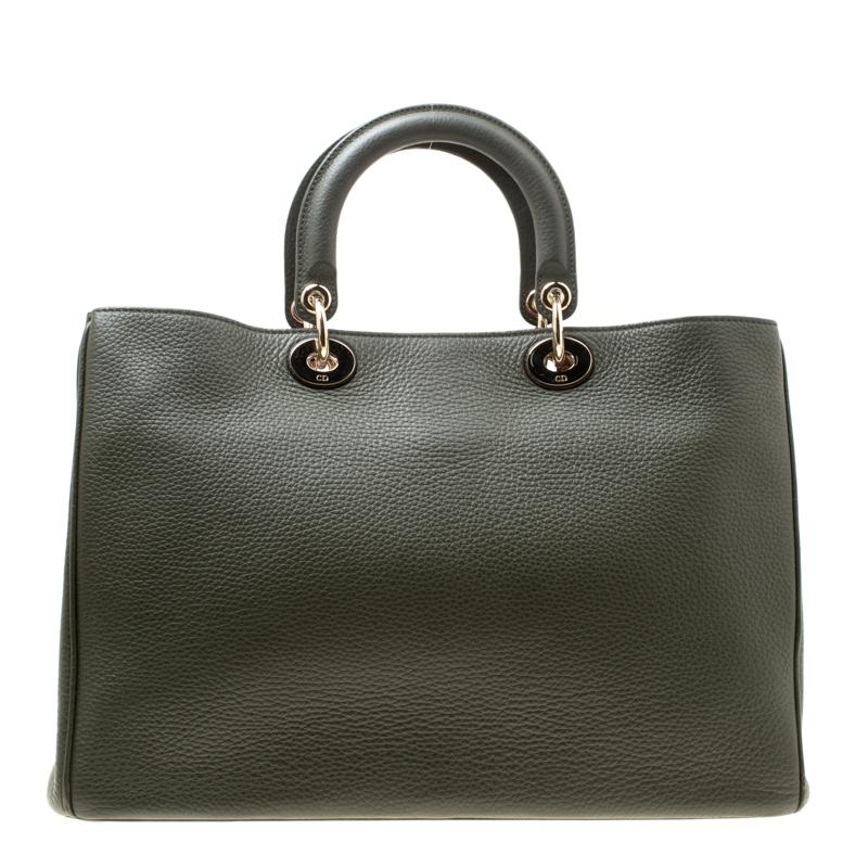 The Diorissimo bag from Dior is a timeless piece. The leather bag comes in a luxurious pine green hue with gold-tone hardware and Dior letter charms. It features double top handles, a detachable shoulder strap and protective feet at the bottom. A