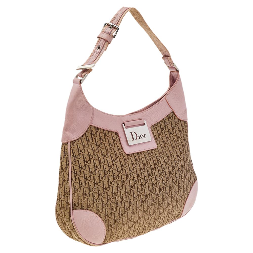 Modernize your wardrobe by adding this Diorissimo hobo to your collection. This creation from the House of Dior is absolutely gorgeous and is the best alternative to carry your daily essentials. Made with the beige-pink signature canvas and leather