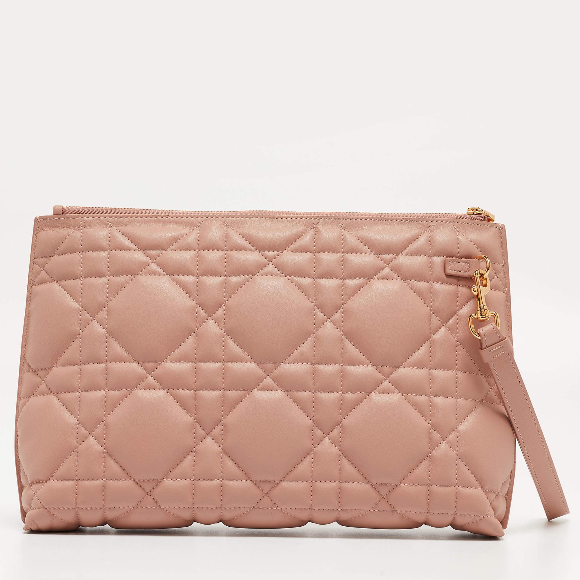 Introducing the Dior Caro D-Every Pouch, a stunning accessory that seamlessly combines style and functionality. Crafted with exquisite pink Cannage leather, this spacious pouch boasts a timeless design, perfect for adding a touch of luxury to any