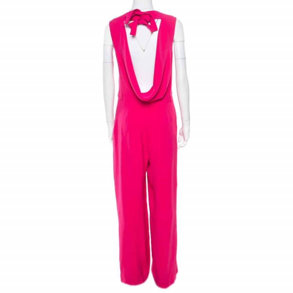 Hold the attention of everyone as you walk into a room wearing this charming jumpsuit from Dior. Look smart and appealing in this pink outfit which is styled with a draped back accented beautifully with tie detail at the neckline. Dazzle your way