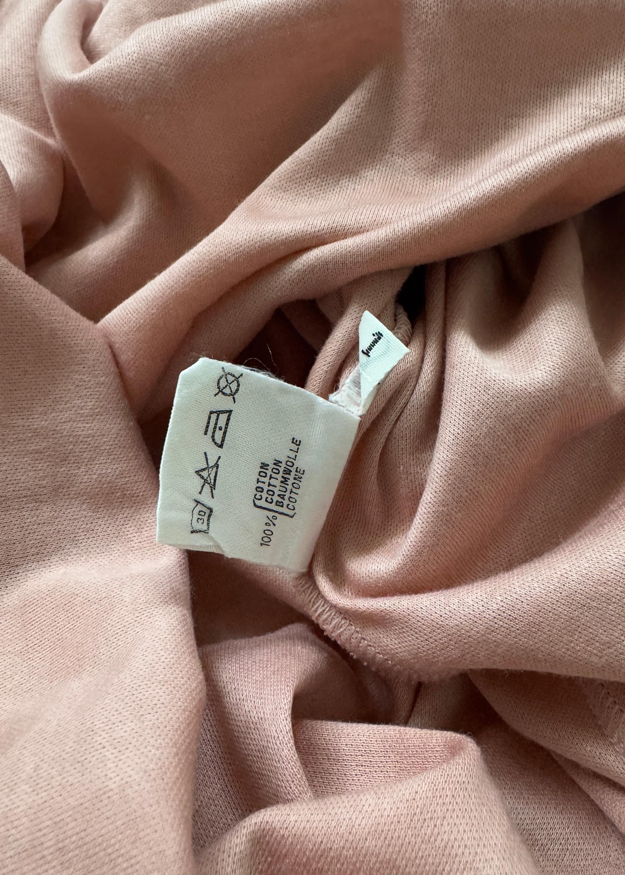 This rare vintage Dior T-shirt captures the playful yet refined spirit of early 2000s fashion. Made from a soft, lightweight cotton-blend jersey in a dusty rose hue, it features a slightly fitted silhouette and short sleeves that flatter the form