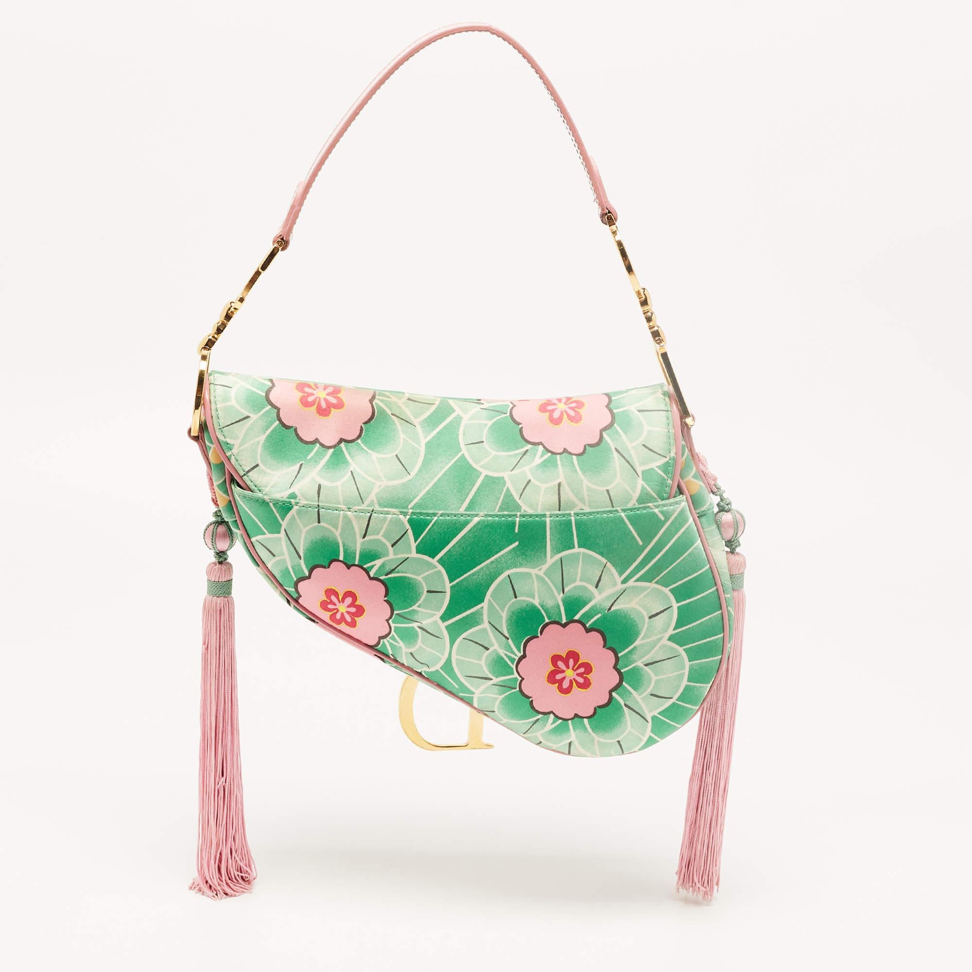 Designed by John Galliano, the Dior Saddle bag is an investment-worthy creation and an icon in the world of handbags. Here, we have a splendid limited edition version of the bag. It is made from printed satin & glazed leather and detailed with pink