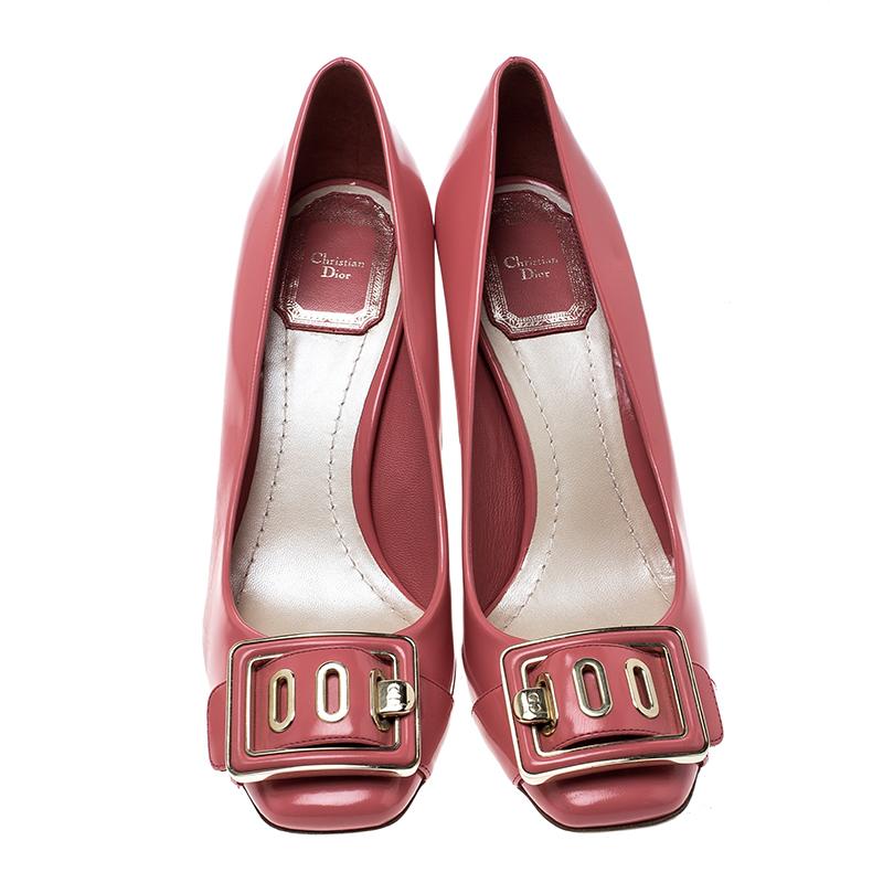 Be it a formal dress or a pantsuit, these Dior pumps are sure to add an extra edge to your looks. Set on a comfortable block heel, this piece is crafted from a patent pink leather body and detailed with a gold-tone buckle on the front. It comes with