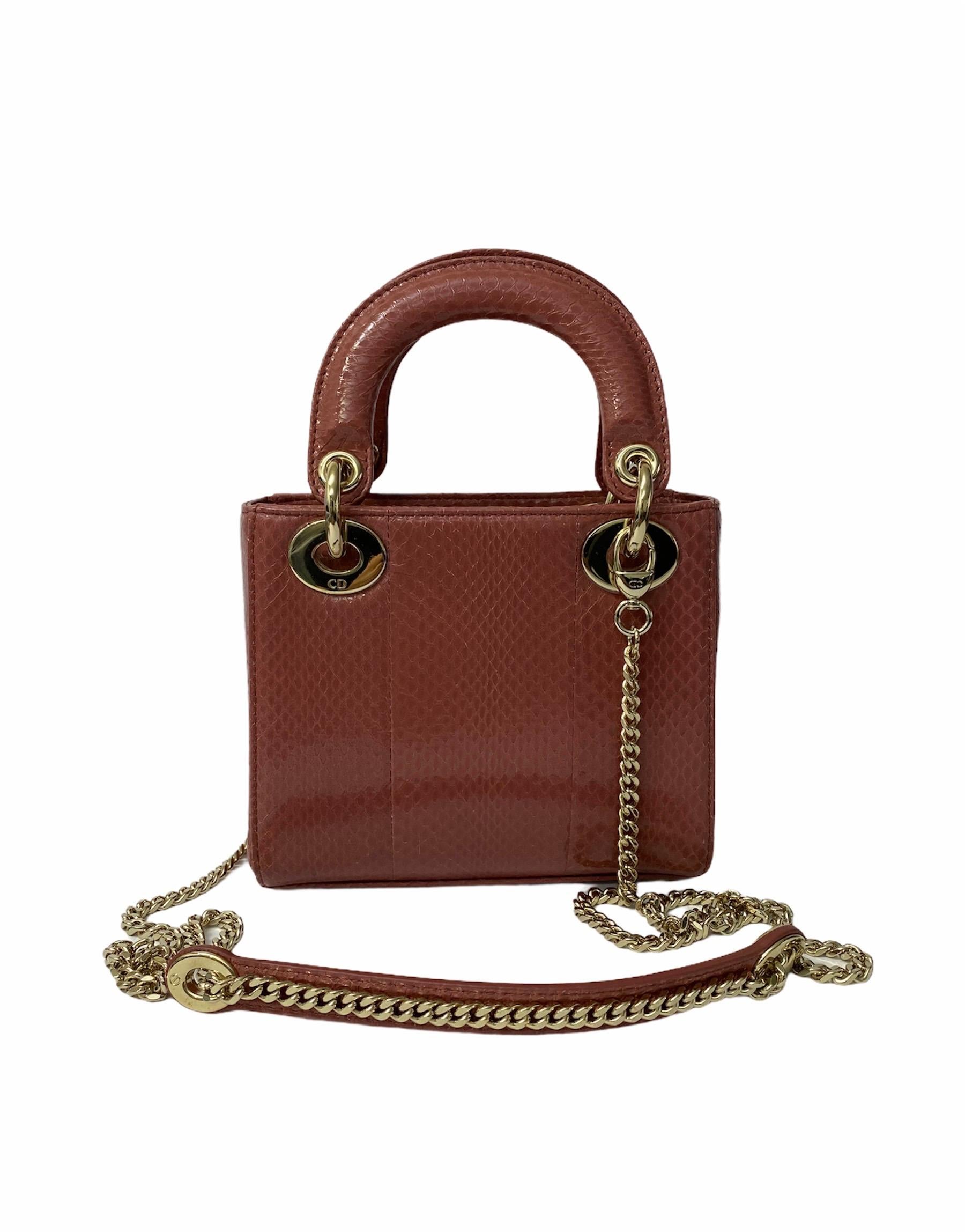 Bag signed Dior, Lady line, made of antique pink patent leather with golden hardware. The product has no closure, internally lined in pink suede, roomy for the essentials. It also has two rigid handles, a removable patent and chain shoulder strap