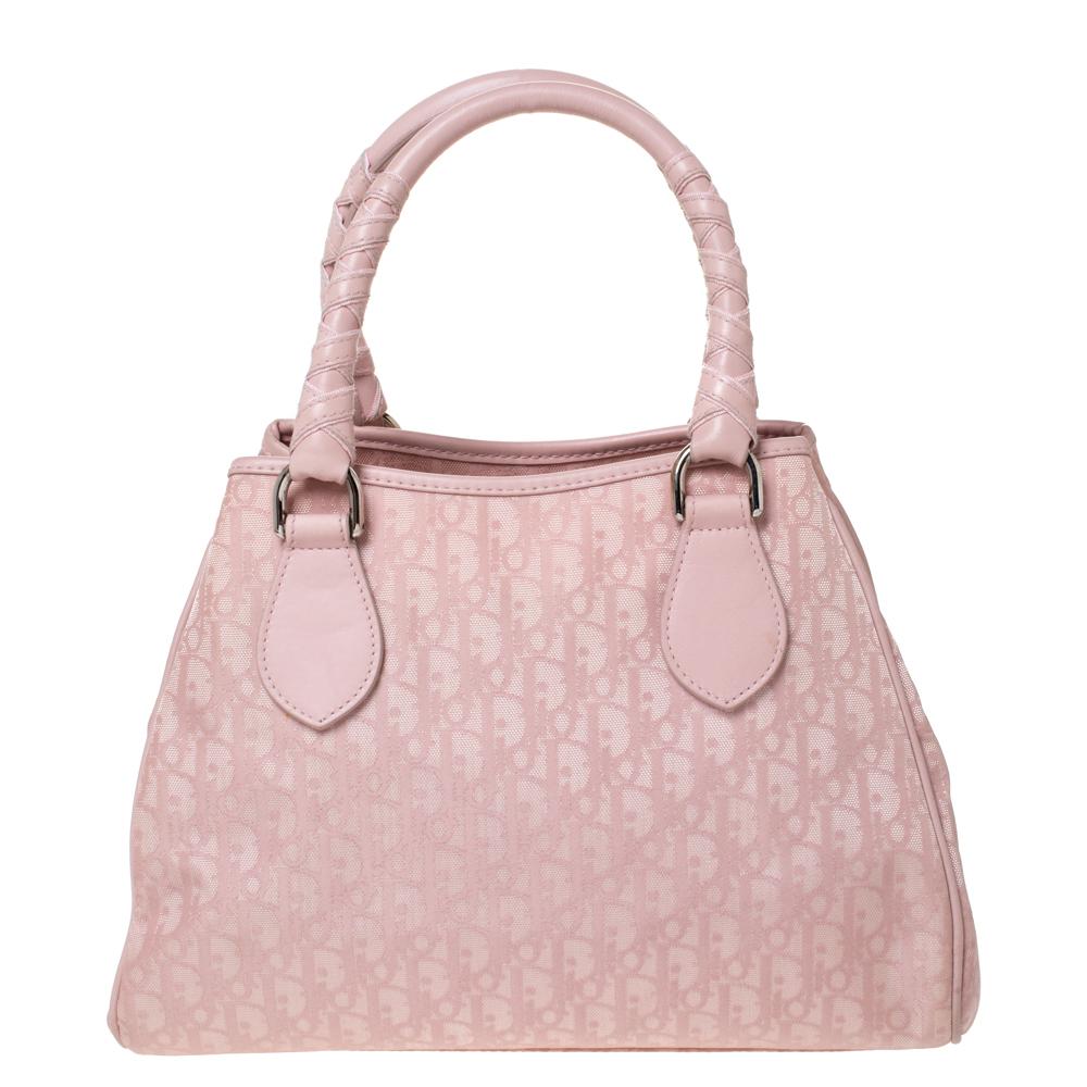 Carry this Lovely Tote by the house of Dior. Crafted from signature Oblique nylon and leather, this bag is equipped with two rolled handles. It is accented with a Dior charm. Another great feature is the magnetic snap lock located on the top of the