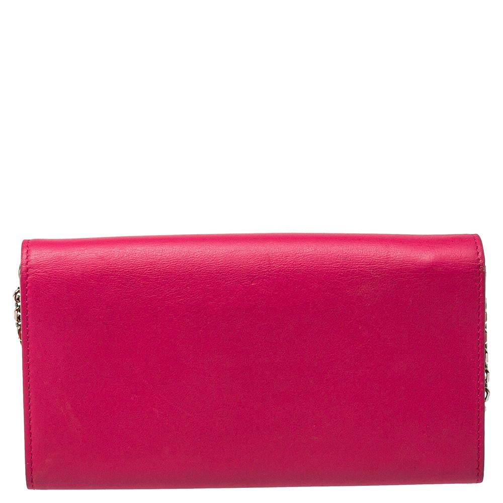 This Addict Rendez-Vous clutch bag from Christian Dior has a petite size but a charming look. Crafted from pink and orange leather, it features a CD stud on the front and is held by a chain. The flap opens to an interior that houses a zipper pocket