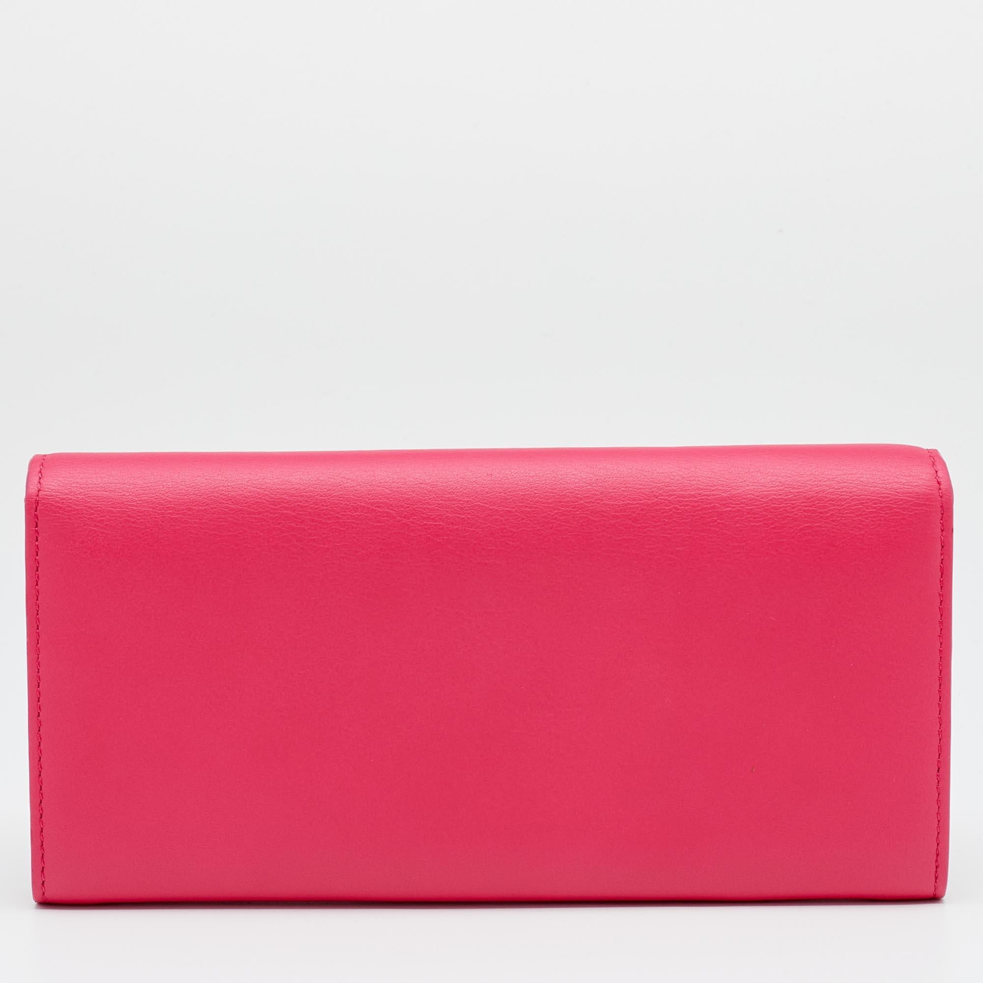 This Addict Rendez-Vous clutch bag from Christian Dior has a petite size but a charming look. Crafted from pink and orange leather, it features a CD stud on the front and is held by a chain. The flap opens to an interior that houses a zipper pocket