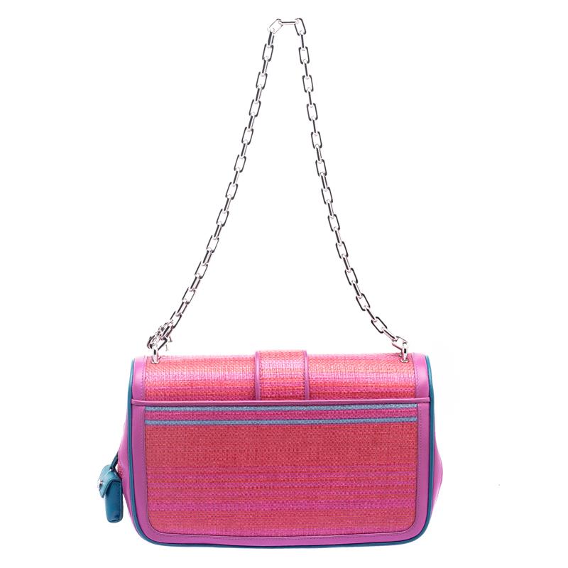Flap bags will never go out of style and that's why this creation from Dior will make a fine buy. Crafted from raffia and leather, this Miss Dior flap bag features a pink/orange exterior and a chain link. The front flap has a Dior lock that opens to
