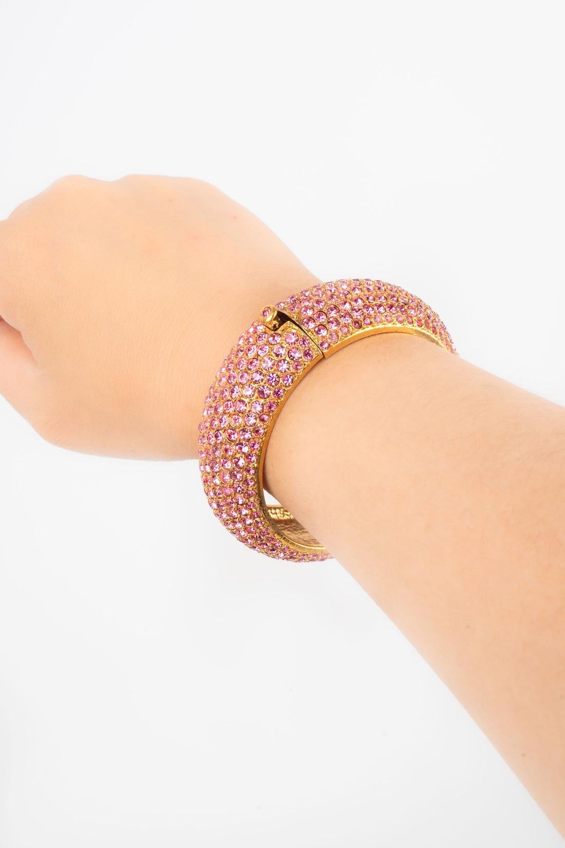 Dior - Golden metal rigid bracelet ornamented with pink rhinestones.

Additional information:
Condition: Very good condition
Dimensions: Circumference: 18 cm

Seller Reference: BRA96