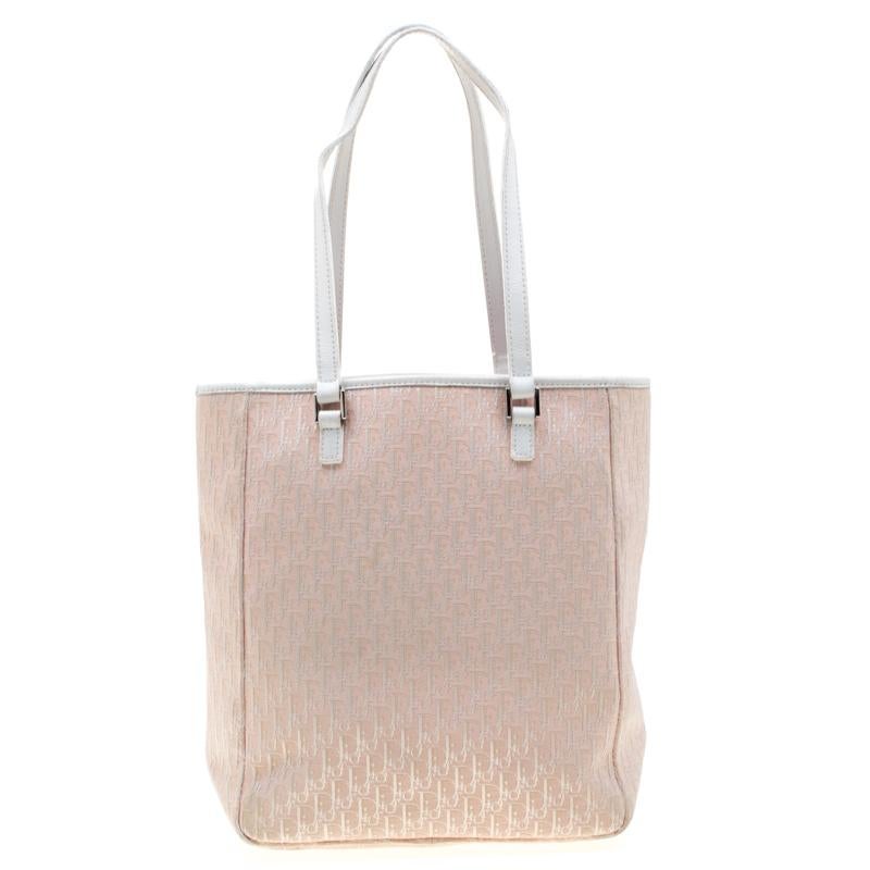 Coming from the house of Dior, this tote ensures comfort and style. Crafted from Diorissimo canvas the tote is enhanced with leather. It is held by two handles, features a slip pocket on the front and a nylon lined interior that houses a zip