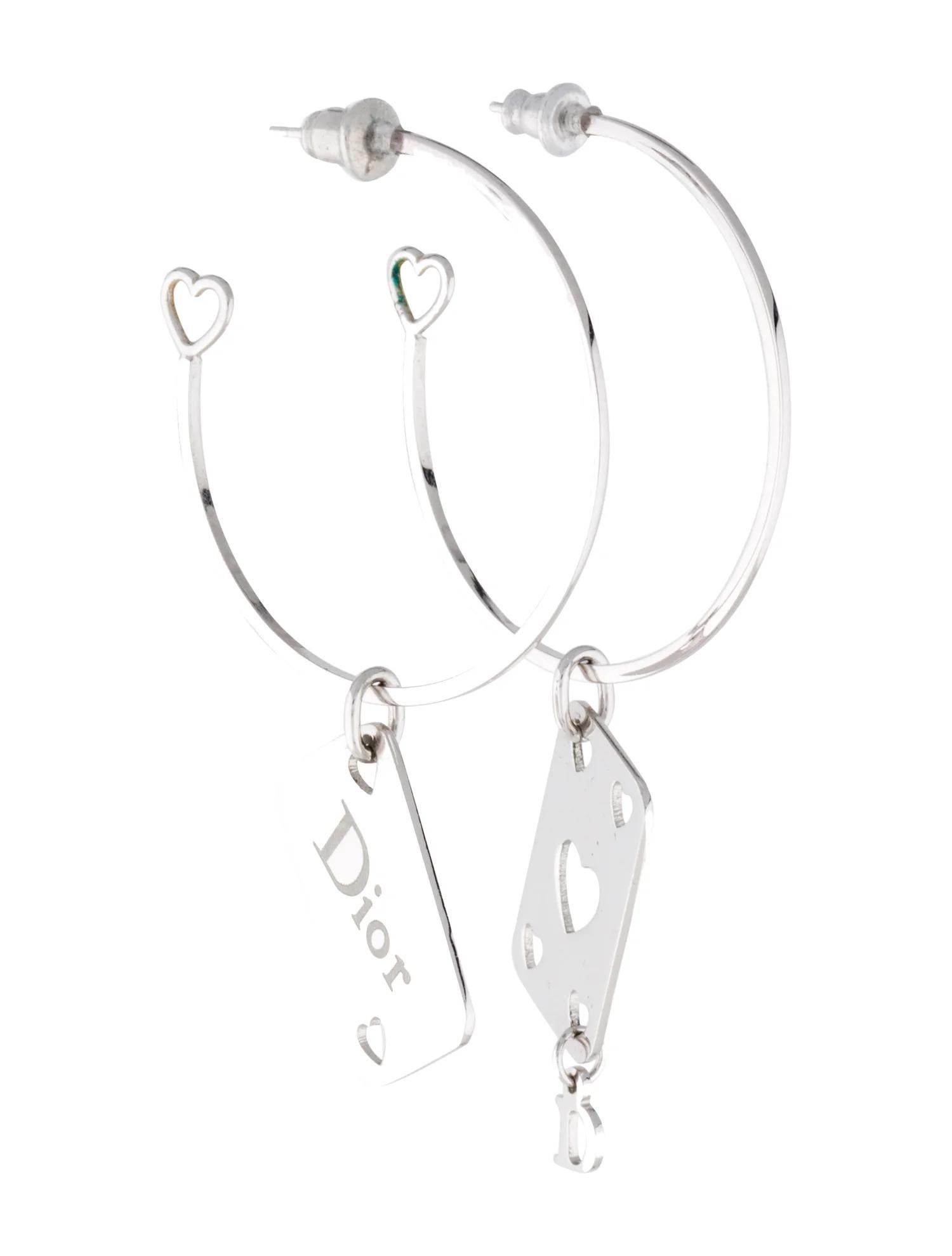 Vintage silver tone earrings featuring dangling poker cards with logo and heart detailing from Christian Dior by John Galliano. Dior written logo on one earring. Good condition with some scratching on either side. 

COLOR: Silver
MATERIAL: Metal