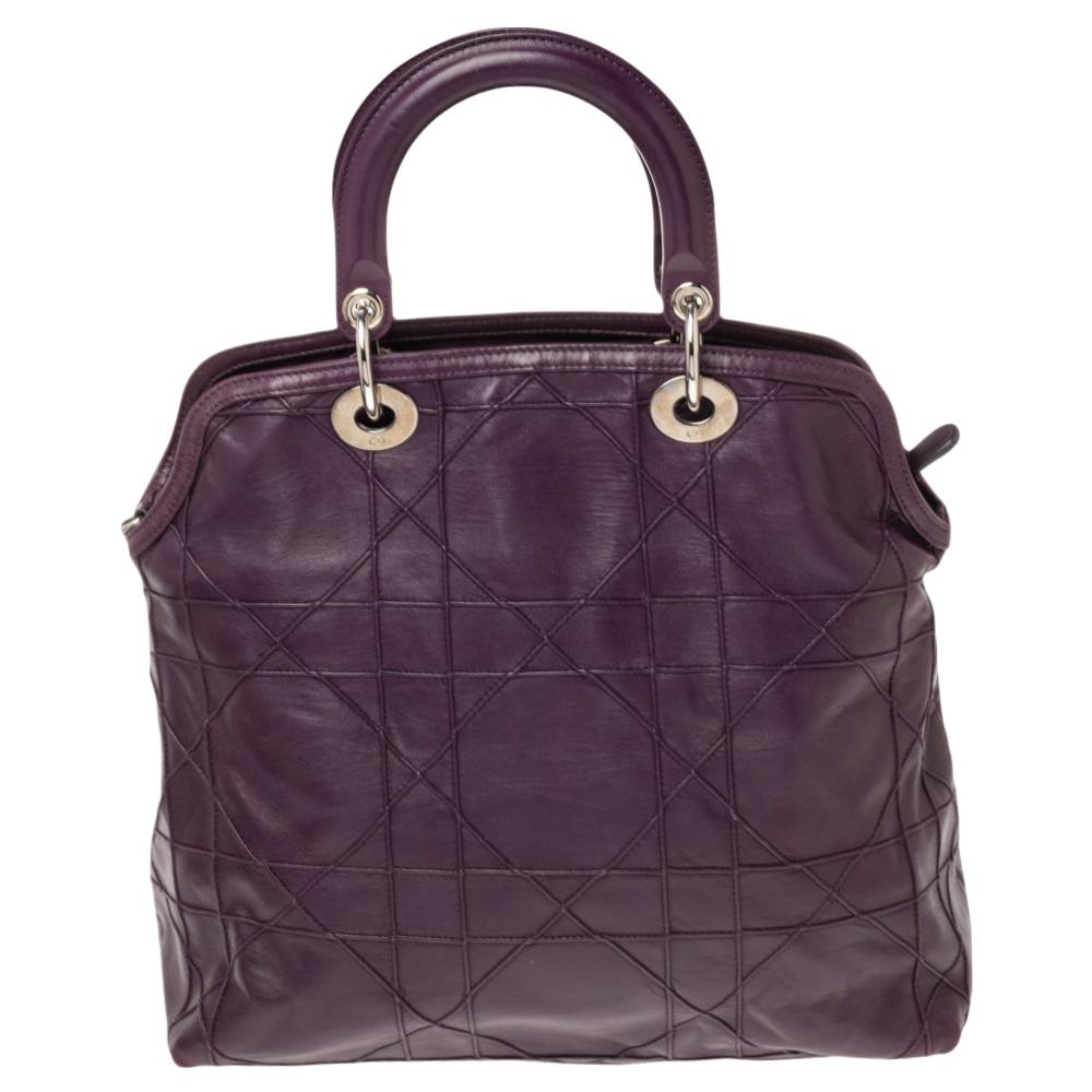 This chic and feminine Granville tote is from Dior. The bag is crafted from Cannage quilted leather. Purple in color, it is easy to carry around. It features dual handles with the signature 'DIOR' accents and protective metal feet. The interior is