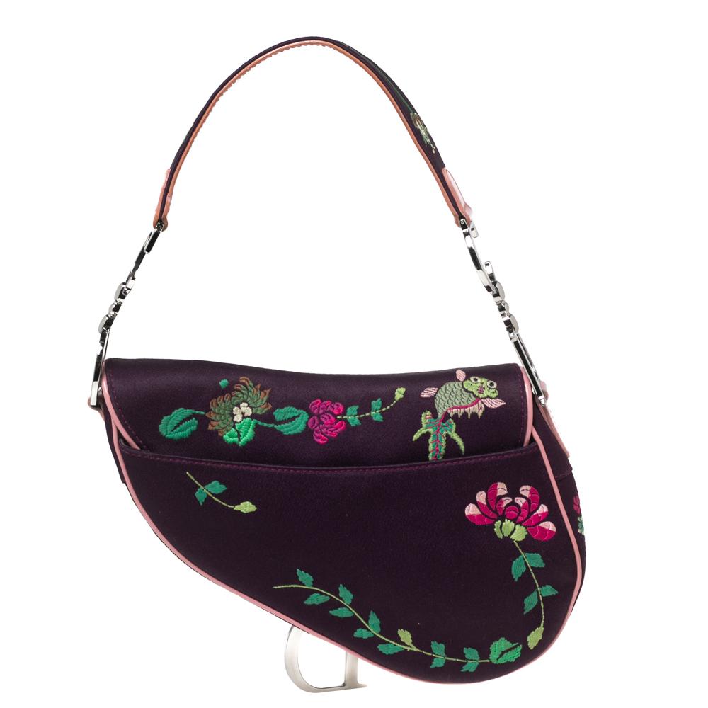 Owing to its uniquely-crafted silhouette and timeless elegance, the Saddle bag remains one of the most iconic designs from Dior. This Limited Edition 0220 Floral And Koi Saddle bag is carved using purple embroidered silk and leather trims, with a