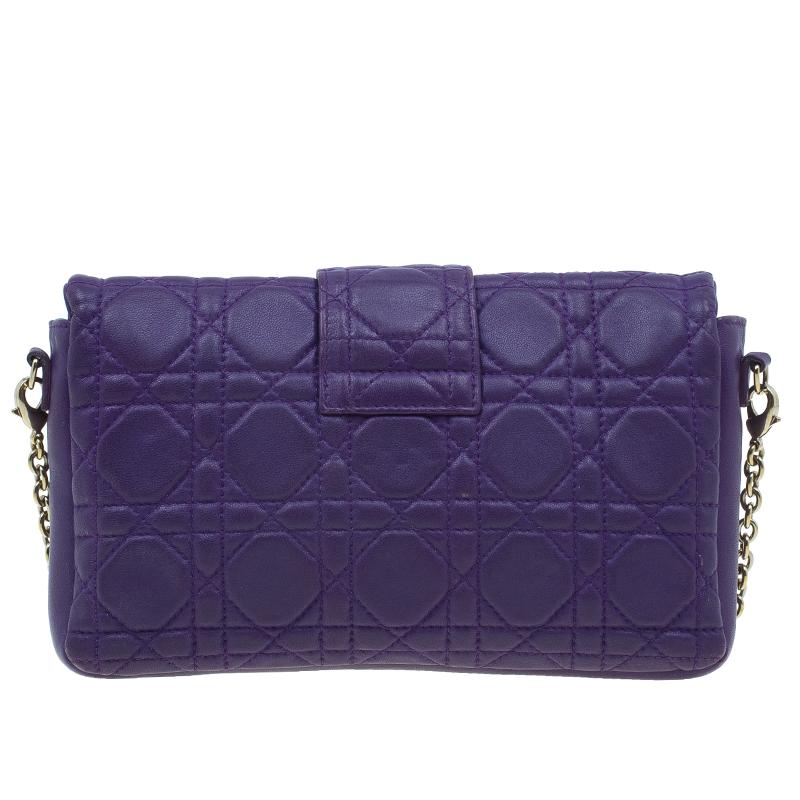 Go for a modern yet ladylike look with this clutch bag from Christian Dior. Crafted from purple lambskin leather, it features distinctive Cannage stitching and a gold-tone hardware push lock closure on the front flap. It comes with a detachable