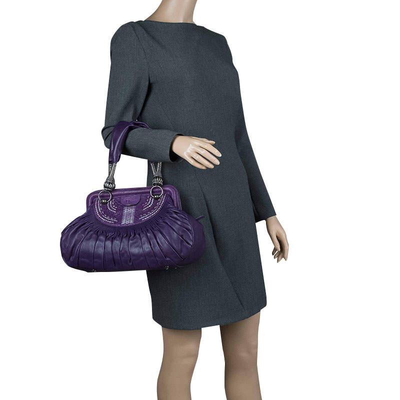 Lancé en 2008, le sac Dior Plisse est intemporel grâce à ses détails accrocheurs. Ce sac fourre-tout est rehaussé de cuir plissé, de magnifiques broderies et d'un fermoir en acrylique Dior. Il évoque le confort avec ses doubles poignées plates en