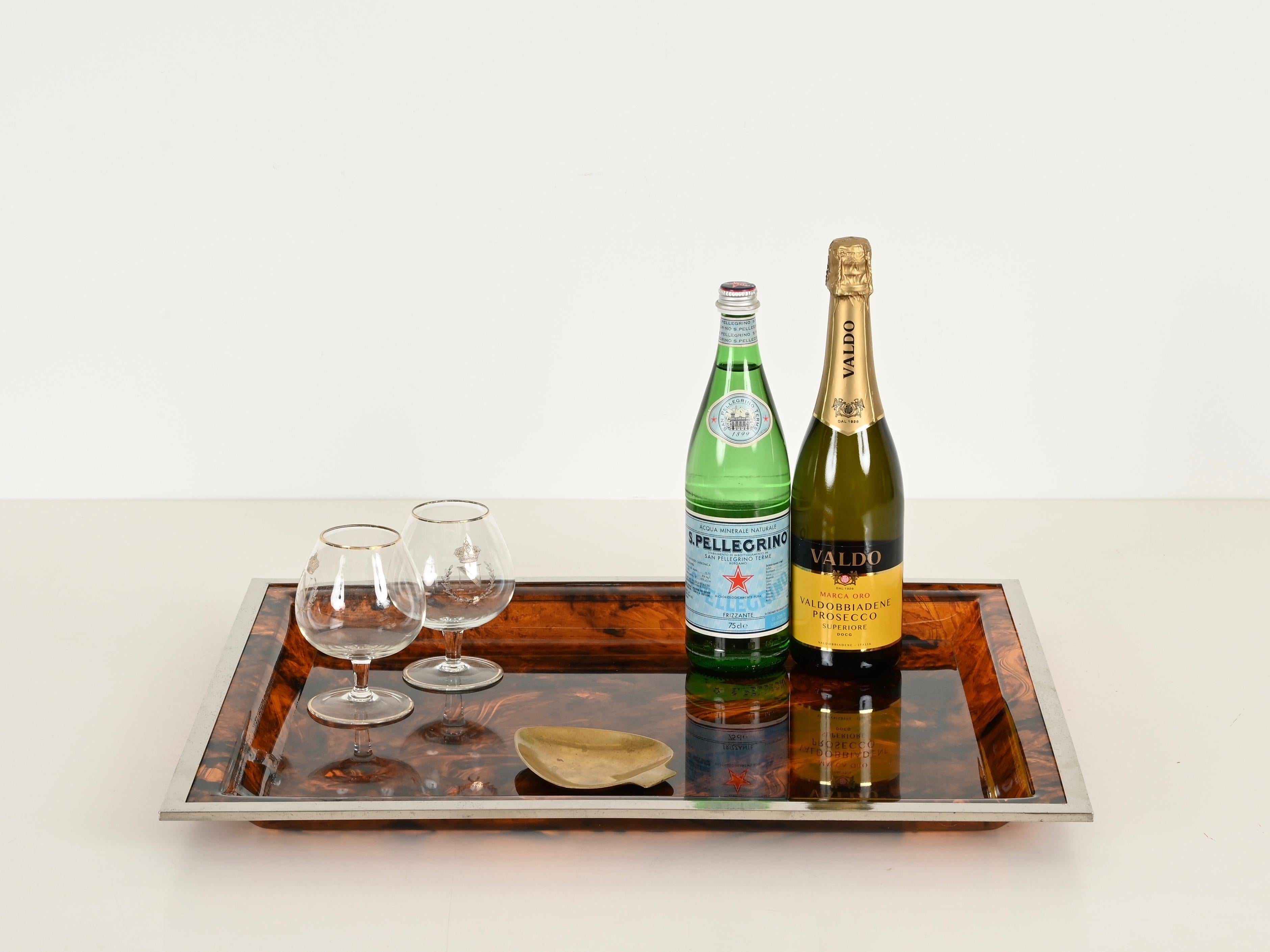 Meraviglioso vassoio da portata del Mid-Century completamente realizzato in vibrante lucite tartarugata con struttura cromata. Questo pezzo incredibilmente elegante è stato disegnato da Dior Home e prodotto in Italia negli anni Settanta.

In ottime