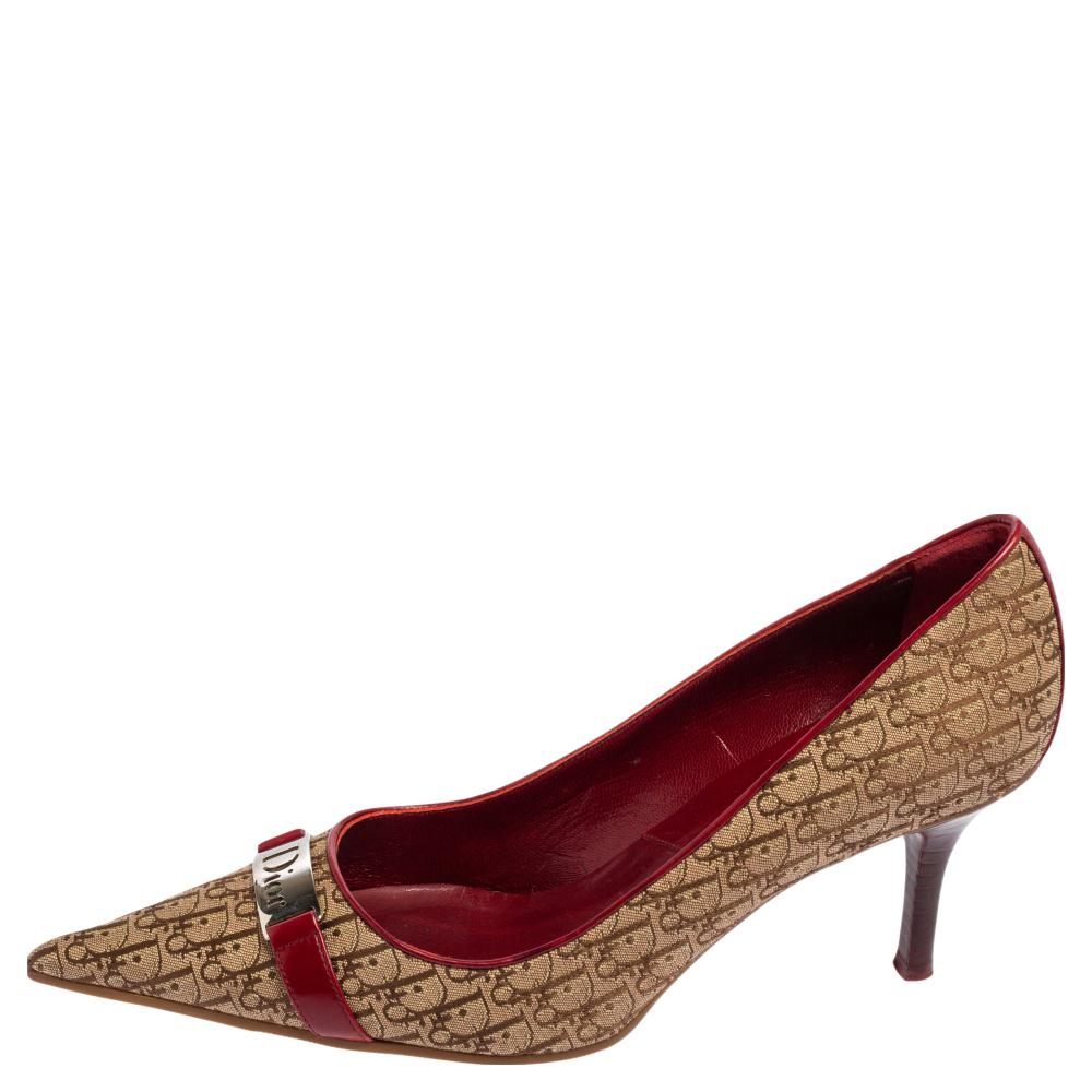 Displaying the emblematic Dior Oblique Monogram canvas and leather on their exterior, these pumps render your feet with signature style and beauty. These beige-red pumps from Dior flaunt a silver-toned logo motif on the front with pointed toes and