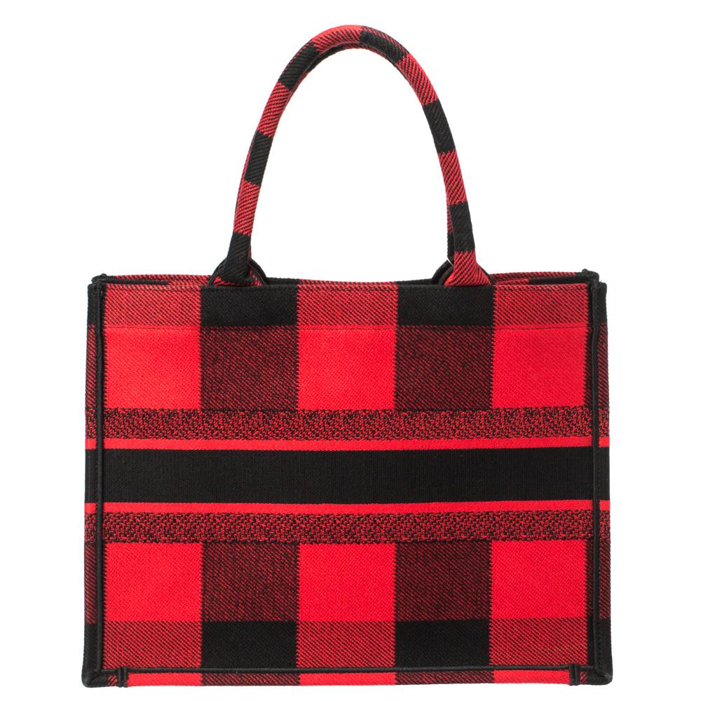 Designed by Maria Grazia Chiuri, the Dior Book Tote is a travel accessory for people with style. The bag here is crafted from canvas into a beautiful structure and covered in plaid patterns all over. Two handles, the 'Christian Dior' signature, and