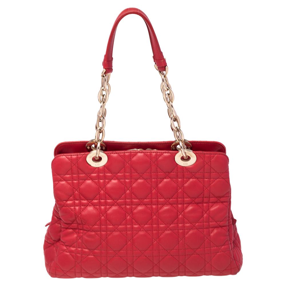 Dieses stilvolle Accessoire ist ein außergewöhnliches Design des Modehauses Christian Dior. Diese aus rotem Leder gefertigte Schönheit stellt die charakteristische Cannage-Steppdecke dar. Sie ist mit einem Logo-Charm auf der Vorderseite verziert,