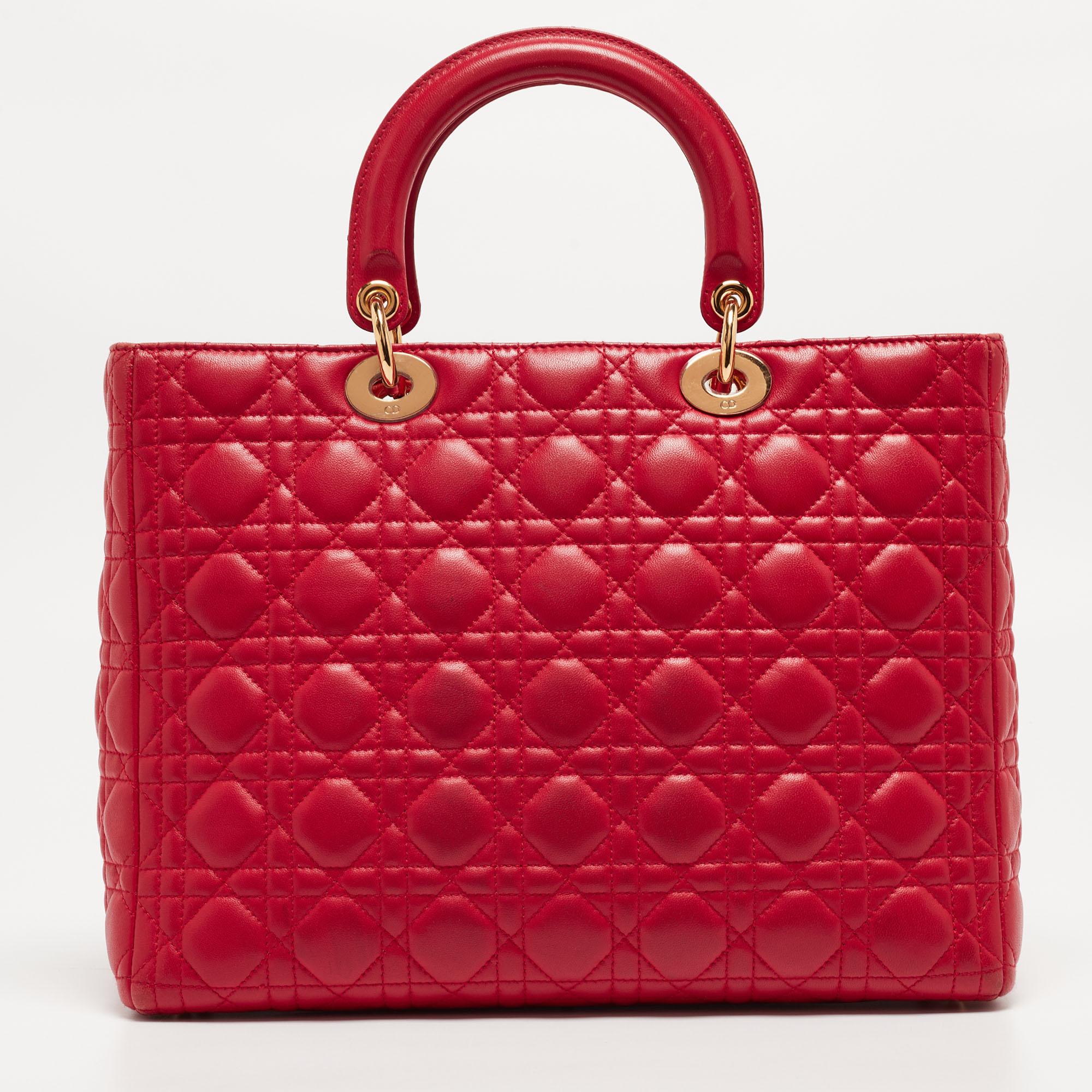 Ein zeitloser Status und ein großartiges Design kennzeichnen die Lady Dior-Tasche. Es ist eine ikonische Tasche, in die die Menschen bis heute investieren. Wir haben hier diese klassische Schönheit aus rotem Cannage-Leder. Die Tasche ist mit