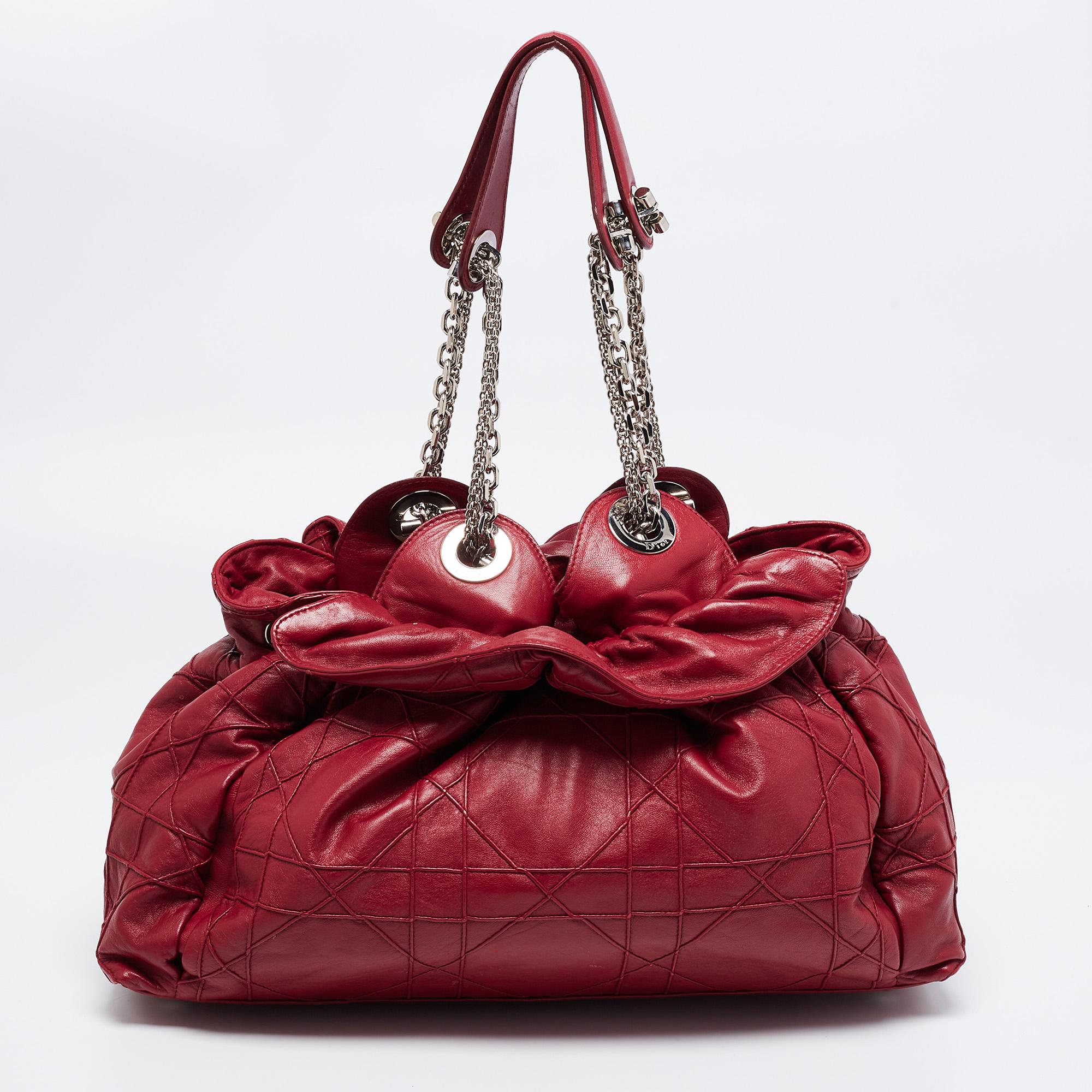 This stylish Le Trente tote from Dior has been crafted from red leather and covered with the signature Cannage motif. The bag features dual chain-leather handles, a 'CD' cutout charm, and protective metal feet. The insides are lined well and sized