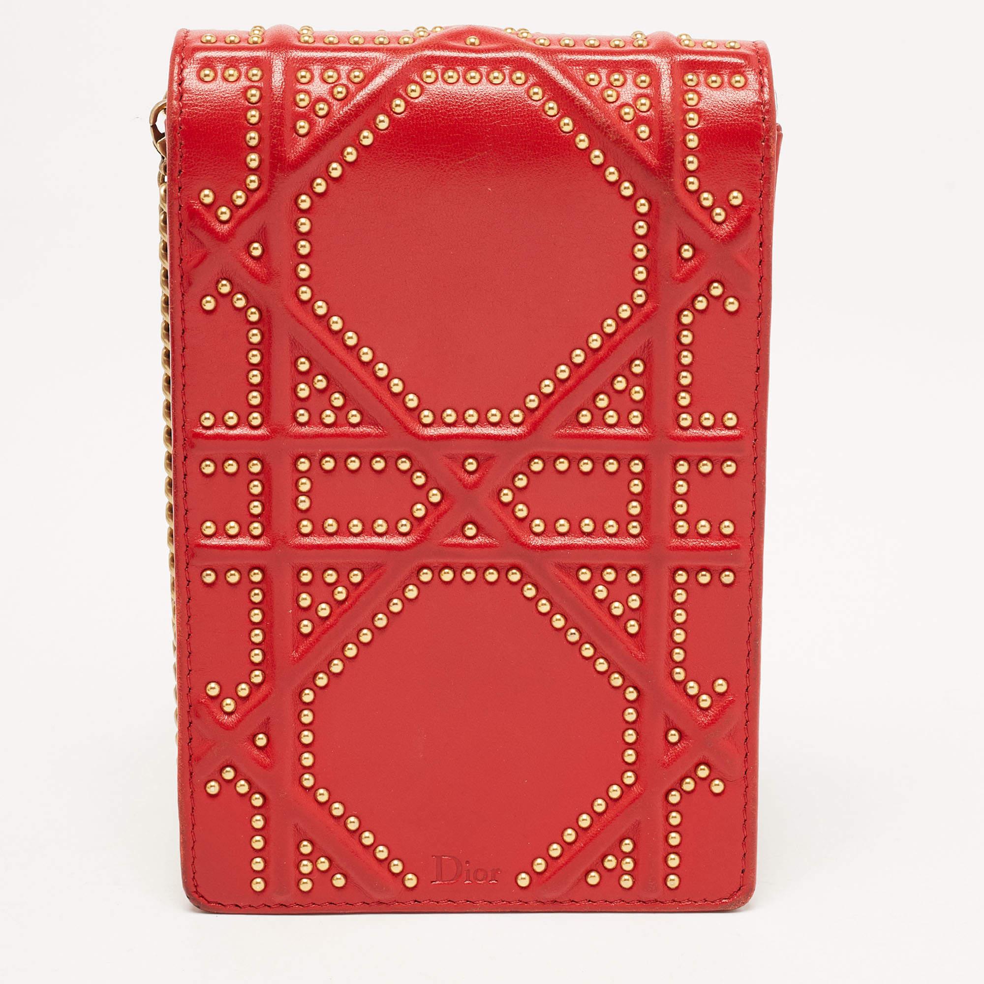 This Diorama clutch is so adorable! It has been crafted from red leather and detailed with studs in the brand's Cannage pattern. The signature crest sits on the flap securing two compartments while a shoulder chain is provided for you to carry it.


