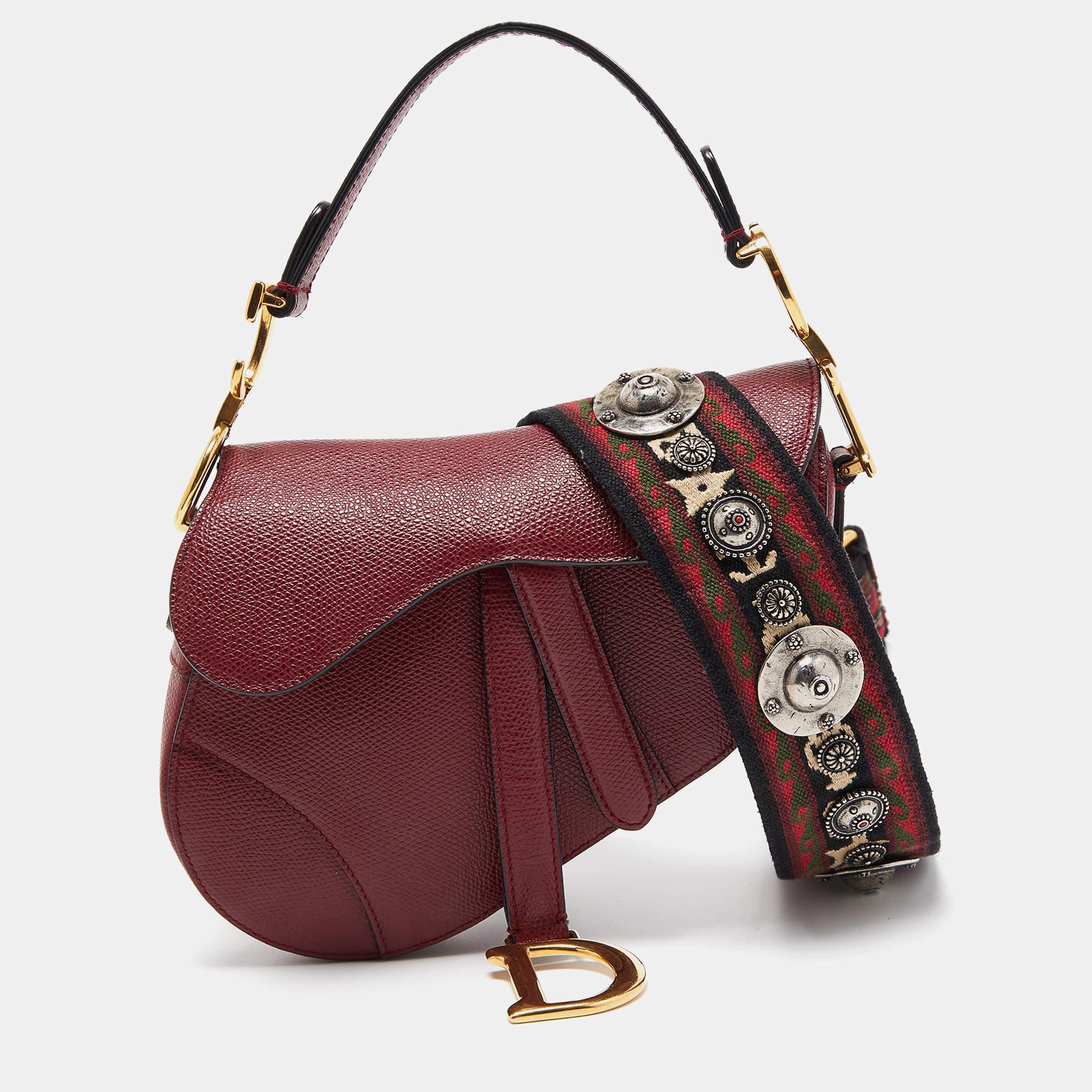 The Dior saddle bag is a chic accessory that epitomizes elegance. Crafted from luxurious red leather, it features the iconic saddle shape, a compact size, and the signature Dior logo. A perfect blend of style and sophistication.


