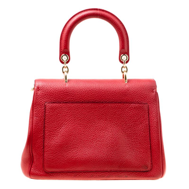 Ravishing in red, this Be Dior bag from the house of Dior is sure to add sparks of luxury to your wardrobe! It is crafted from leather and features a chic silhouette. It flaunts a single rolled top handle with attached 'DIOR' letter charms and comes