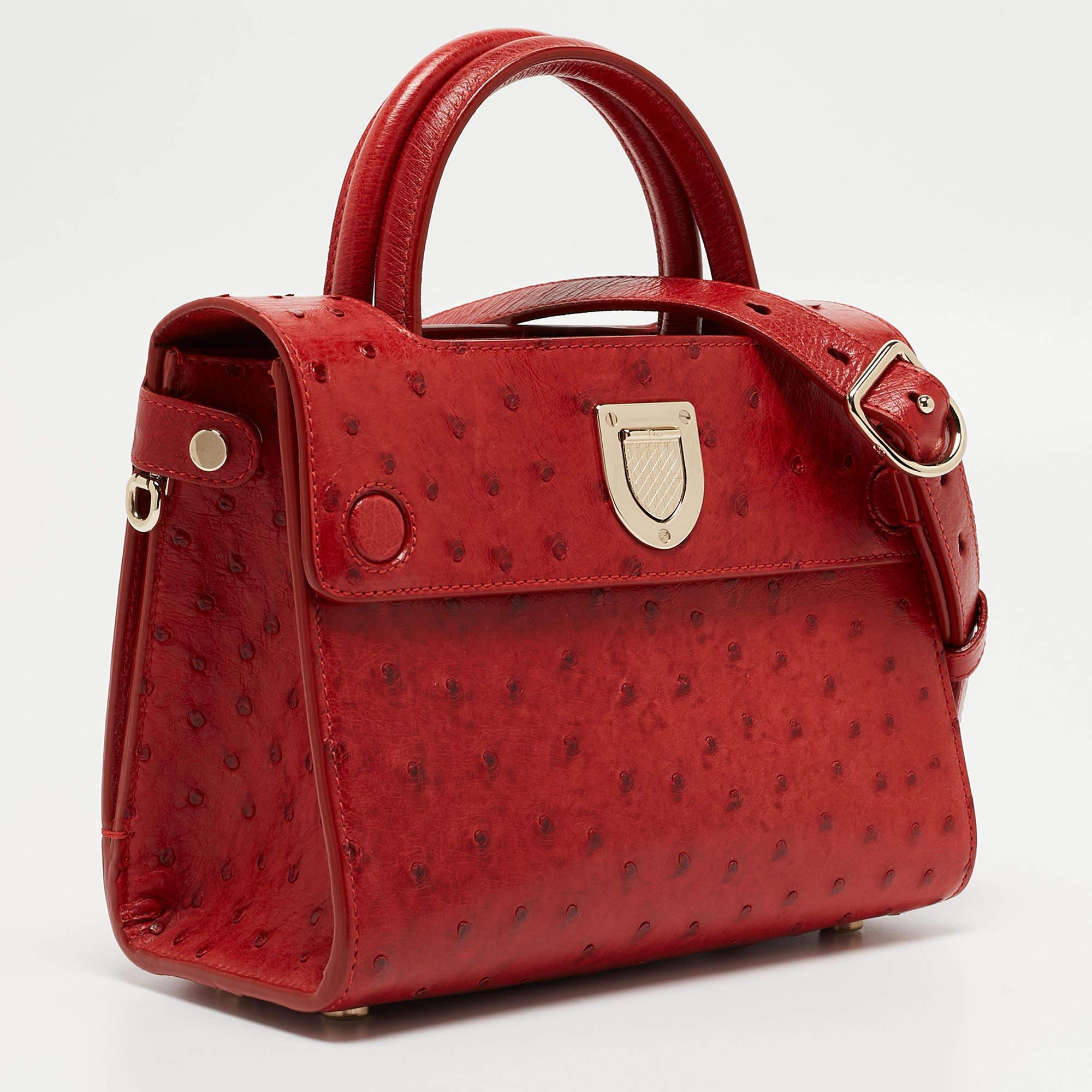 The Dior Diorever tote exudes luxury with its vibrant red ostrich leather and iconic design. The mini size offers a perfect blend of elegance and practicality. The bag features a distinctive crest-shaped clasp, sturdy top handles, and a detachable