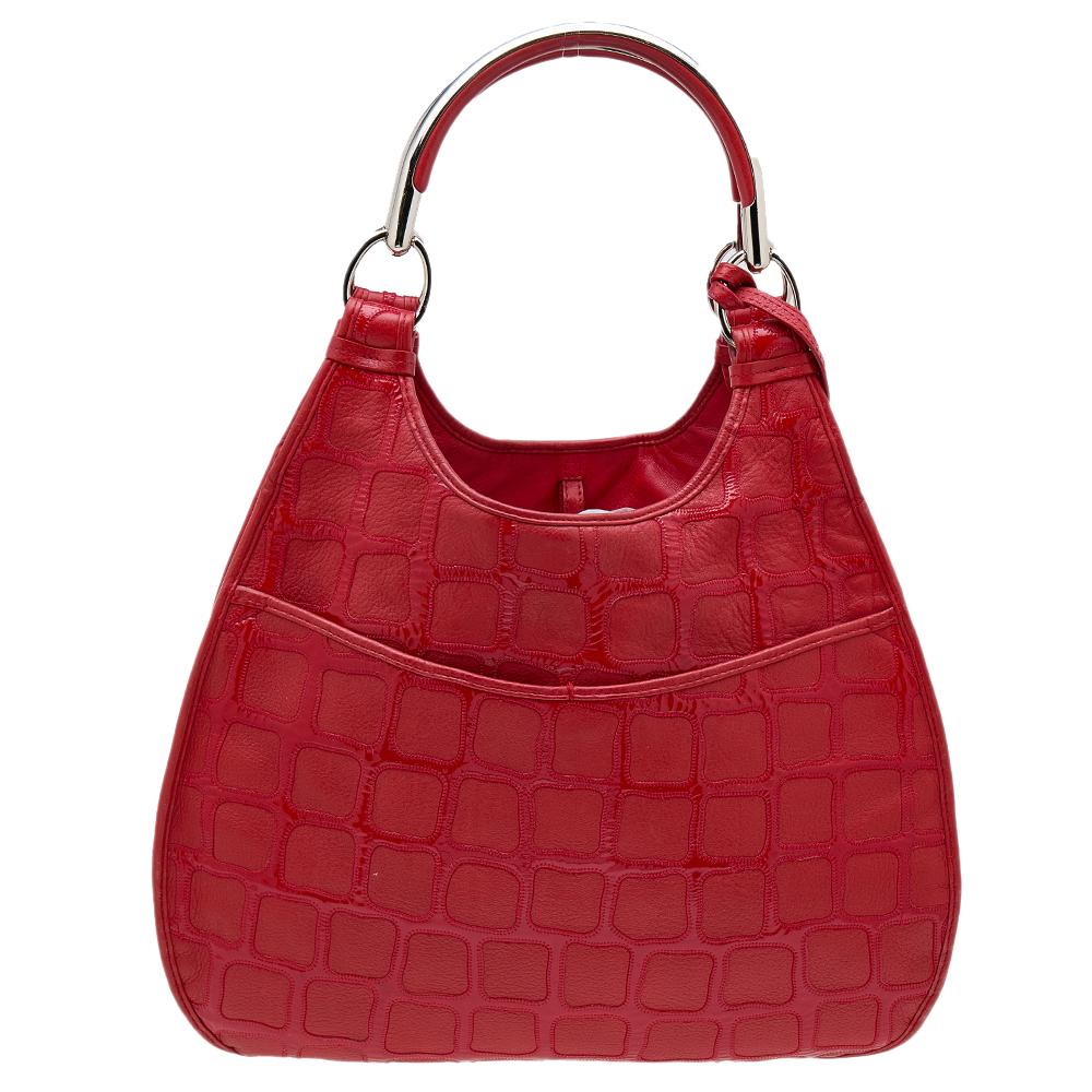 This beautifully stitched tote in croc-embossed leather is by Dior. The tone of red continues to the spacious interior. Two metal handles and a fine finish make this tote a worthy purchase.

