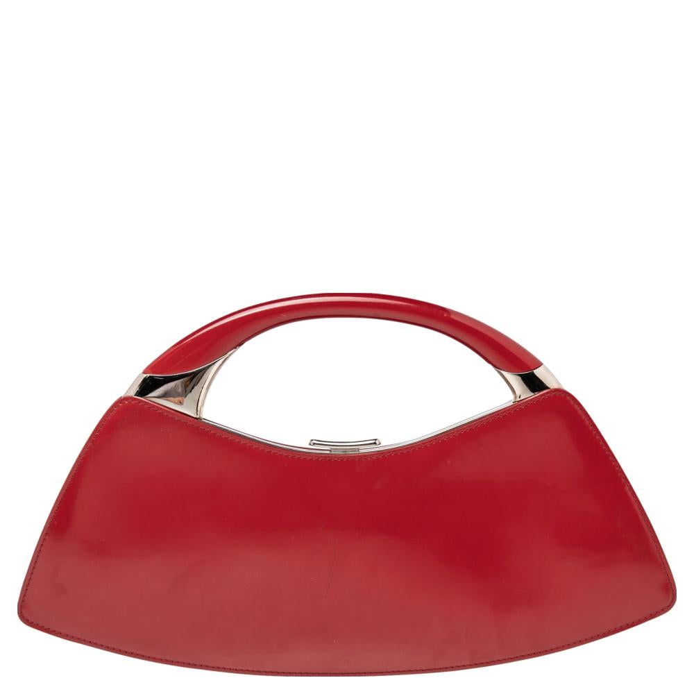An outstanding piece that reflects the choice of a modern woman, this clutch from Dior is absolutely eye-catching. Splendid in red patent leather, the bag exhibits silver-tone brand logo detailing and buckles on the front and the bag opens to a