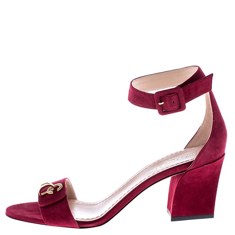 These stunning sandals by Dior are absolute must-have. Crafted from suede, they come in red shade and exude sophistication. They feature buckled ankle straps, 7.5 cm heels, leather-lined soles, and a classic open-toe silhouette. The straps are
