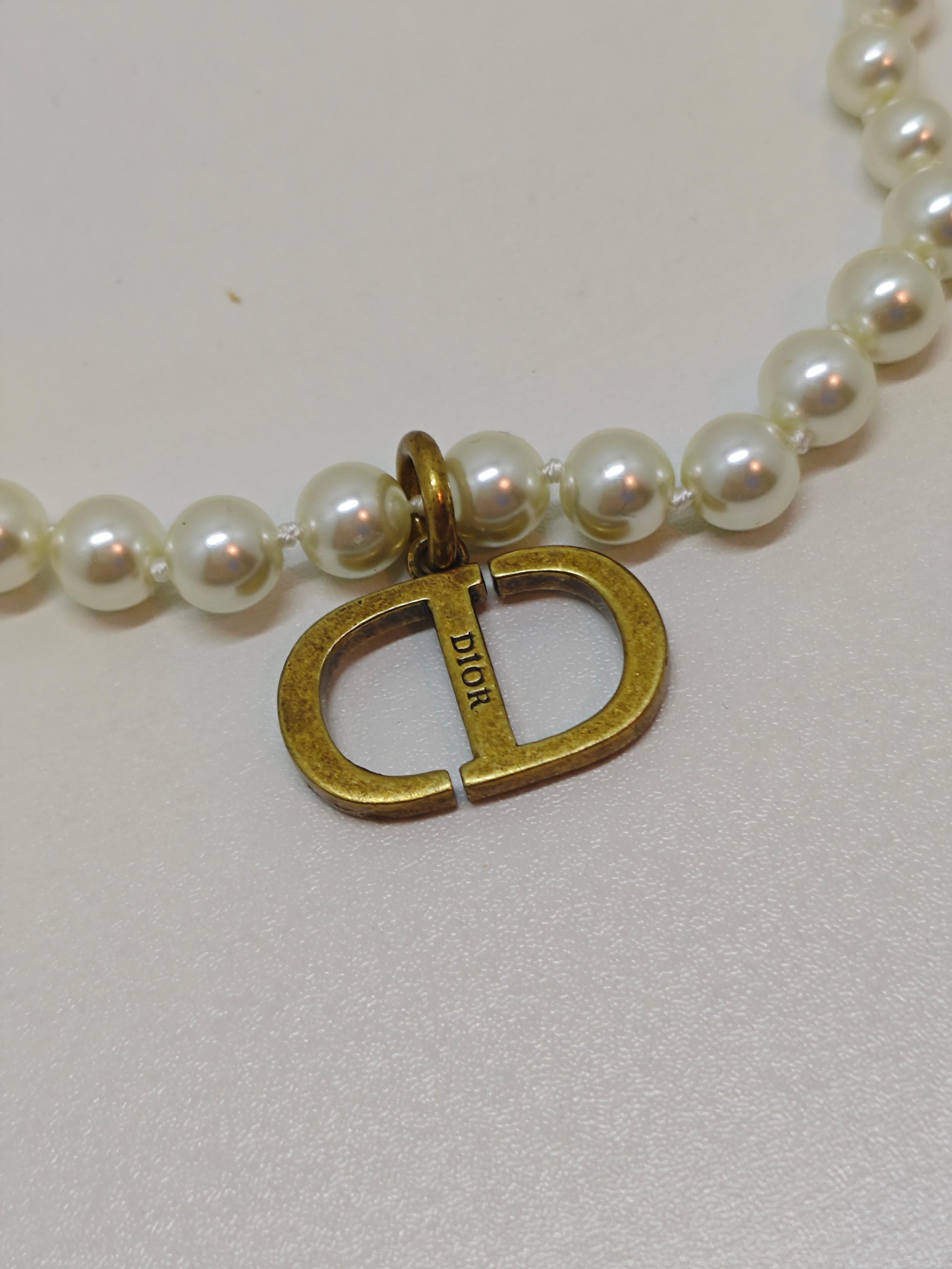 Exude timeless elegance with this exquisite Dior Rhinestone Antique CD Pearl Choker Necklace. A true statement piece, this vintage-inspired choker features a stunning CD logo centerpiece, encrusted with shimmering crystal rhinestones for a touch of