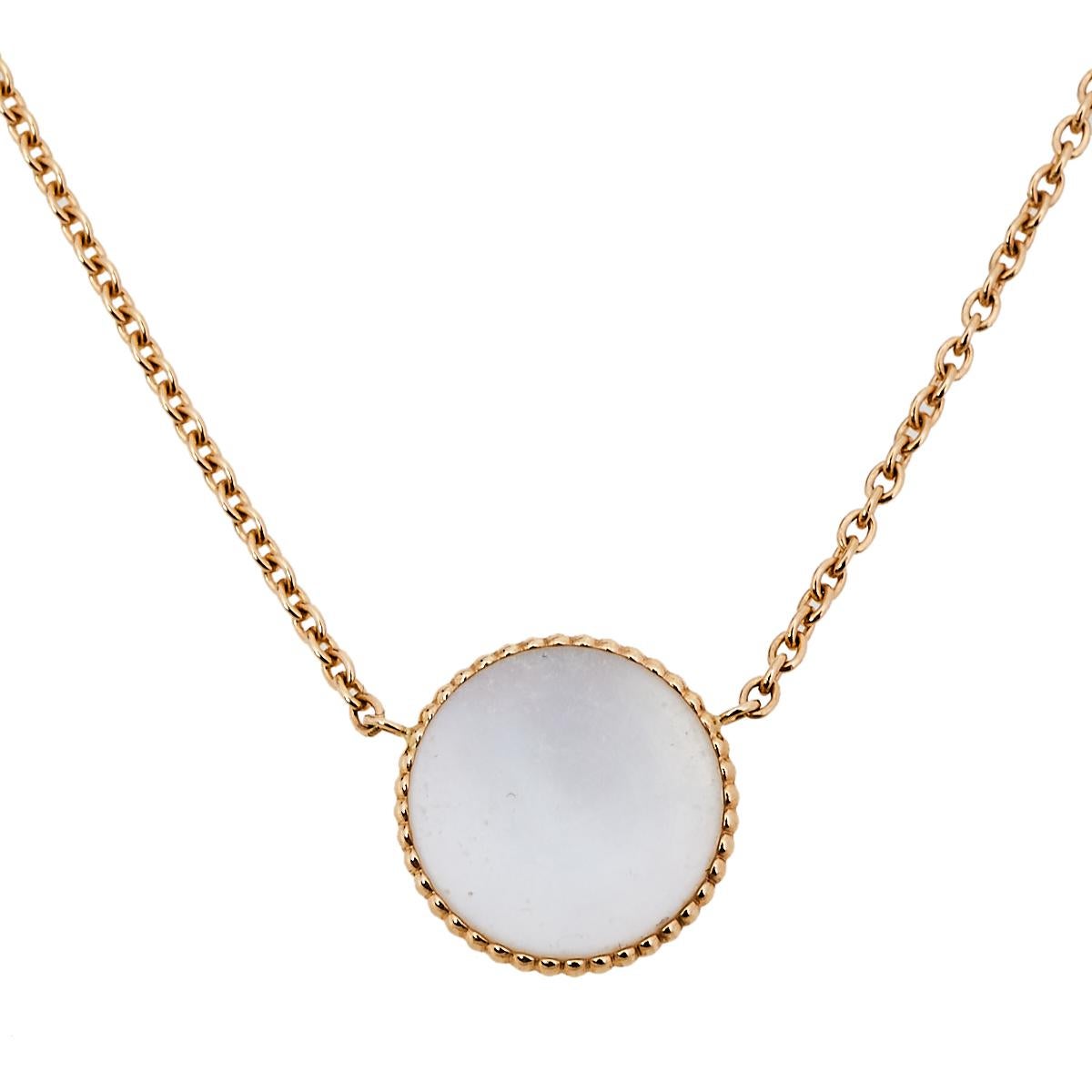 This Rose des Vents necklace by Dior exhibits the talisman star as its main highlight. The necklace's design features a round pendant inlaid with mother of pearl and outlined with 18k yellow gold beaded borders. The motif is further accented with a