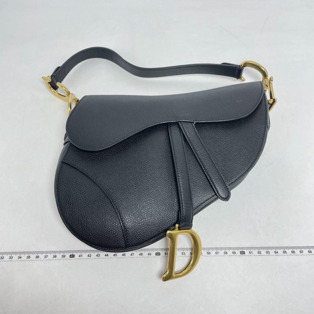 Dior Saddle Black Medium Grained Leather Handbag with Gold Hardware with Strap
 These are professional photos of the actual bag offered by Luxbags.
 
 2018 Dior Saddle bag, crafted in black grained calfskin leather, the legendary design comes in