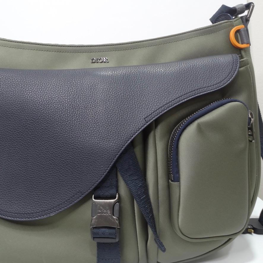 Amazing Dior mens shoulder bag with a black leather saddle style closure! In a stunning muted army green color contrasting black leather and silver hardware. This bag is perfect for traveling, featuring a spacious center opening that zips, three
