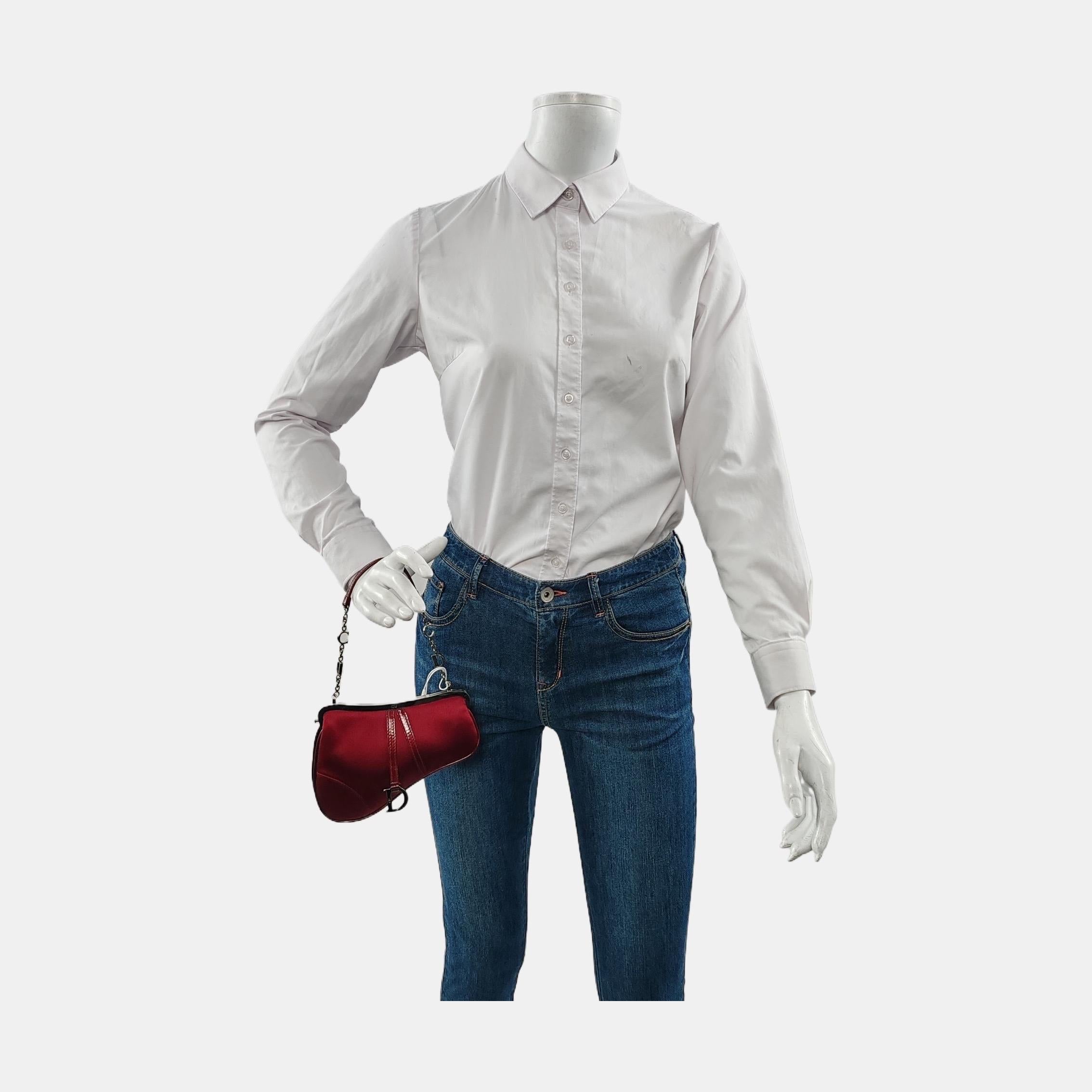 Bolso Dior Saddle, confeccionado en satén de seda rojo, el legendario diseño se presenta en tamaño mini, tiene una abertura con cierre magnético y una fina correa de charol y cadena Christian Dior plateada. Este bolso Saddle tiene mucha clase y es
