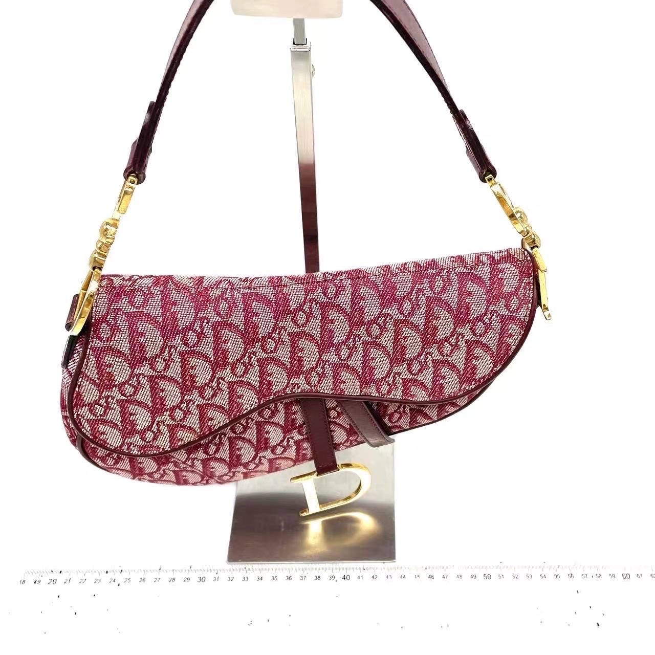 The Dior Saddle Vintage Burgundy Oblique is an iconic kidney-shaped saddle bag, originally designed by John Galliano. Its most iconic feature is the oblique Dior monogram, with silver hardware. This vintage version offers more room and a softer feel