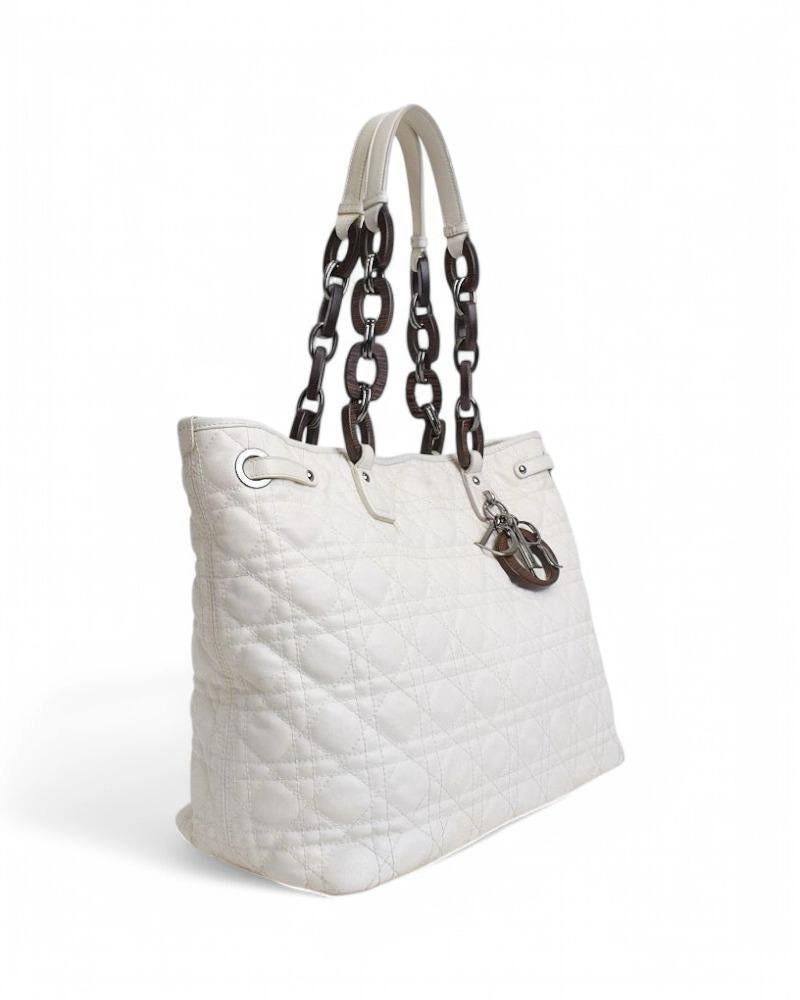 Dior signature bag, Shopper Lady model, made of white fabric with cannage pattern and silver hardware. Featuring a magnetic button closure, internally lined in beige canvas with convenient pockets, the bag is very roomy. Equipped with two leather,
