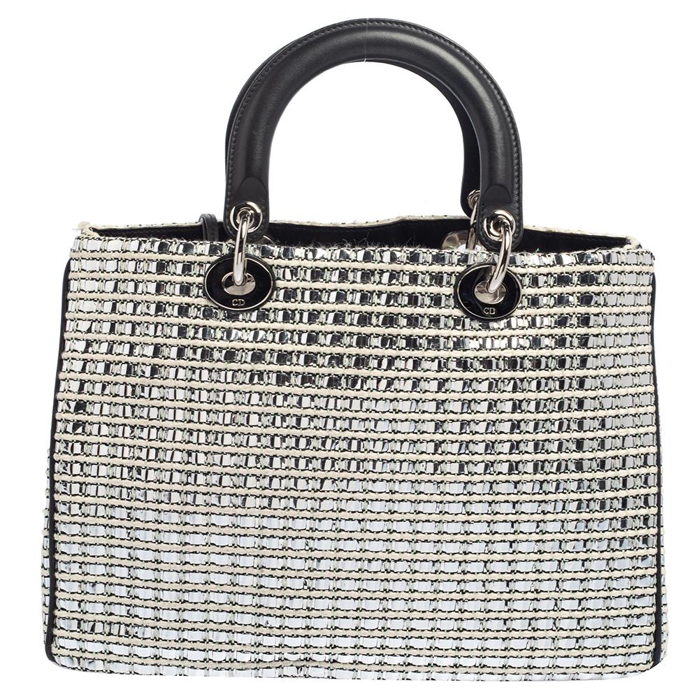 The Diorissimo shopper tote from Dior is a piece that has never gone out of style. The tweed bag comes in a classy silver shade with silver-tone hardware and 'Dior' letter charms. It features double top handles, a detachable shoulder strap, a small