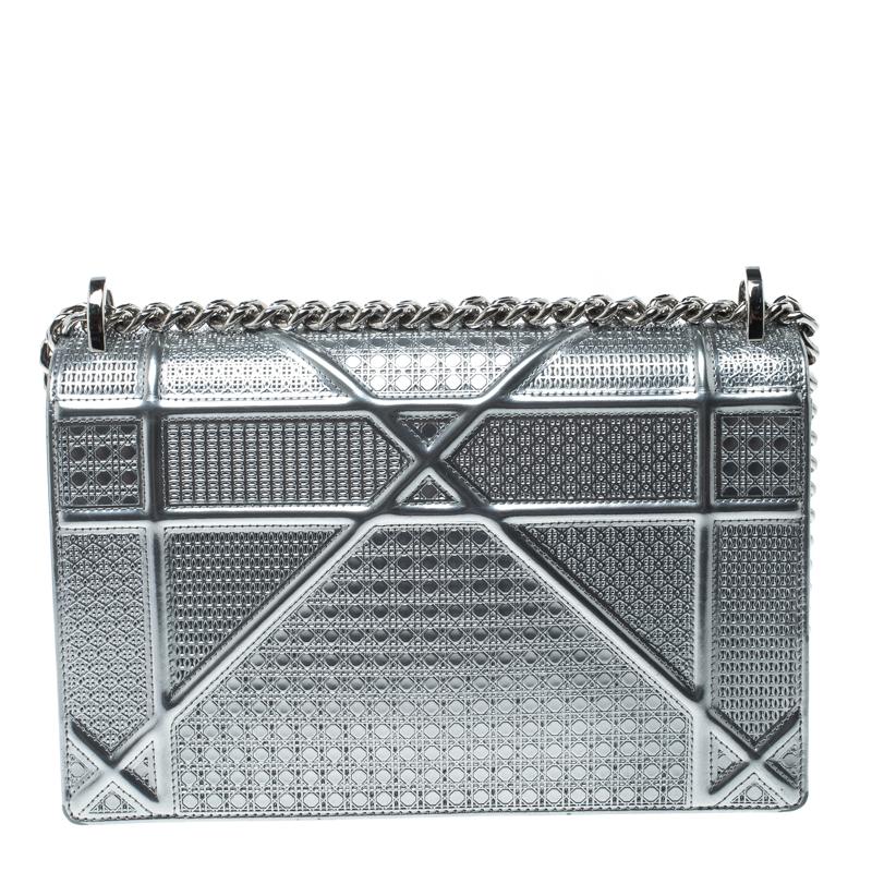 This Diorama bag is simply breathtaking! From its structured shape to its artistic craftsmanship, the bag sweeps us off our feet. It has been crafted from silver patent leather and covered in the brand's signature Cannage pattern. A magnetic closure
