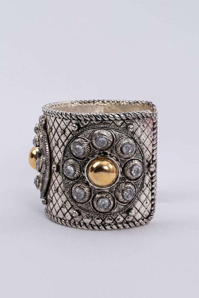Dior - Cuff bracelet in silver plate embellished with rhinestones and gilded metal cabochons.
Collection Prêt-à-porter Printemps-Été 1994.

Additional information:
Dimensions: Circumference: 15 cm (5.9 in) 
Opening: 3.5 cm (1.37 in) 
Height: 5.5 cm