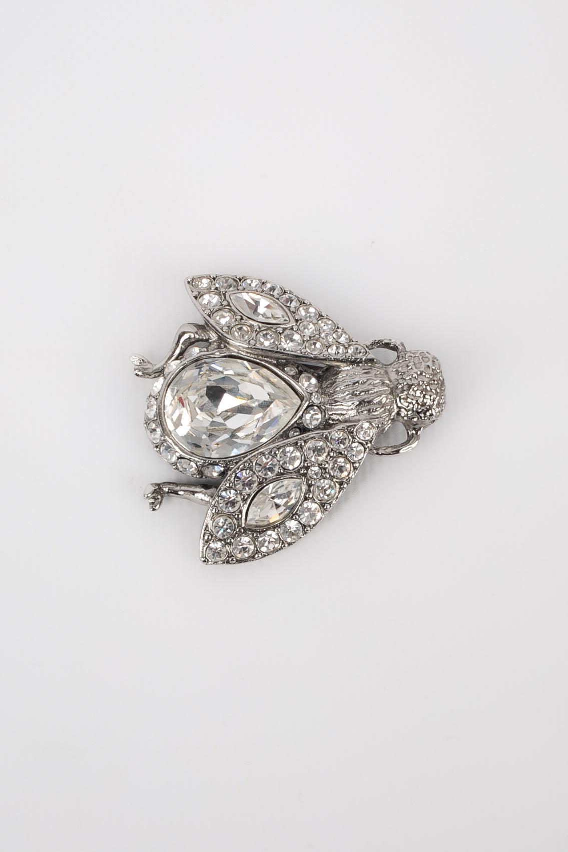 Dior - (Made in France) Silvery metal brooch with rhinestones representing a bee.
 
 Additional information: 
 Condition: Very good condition
 Dimensions: 4 cm x 4.5 cm
 
 Seller Reference: BR48
