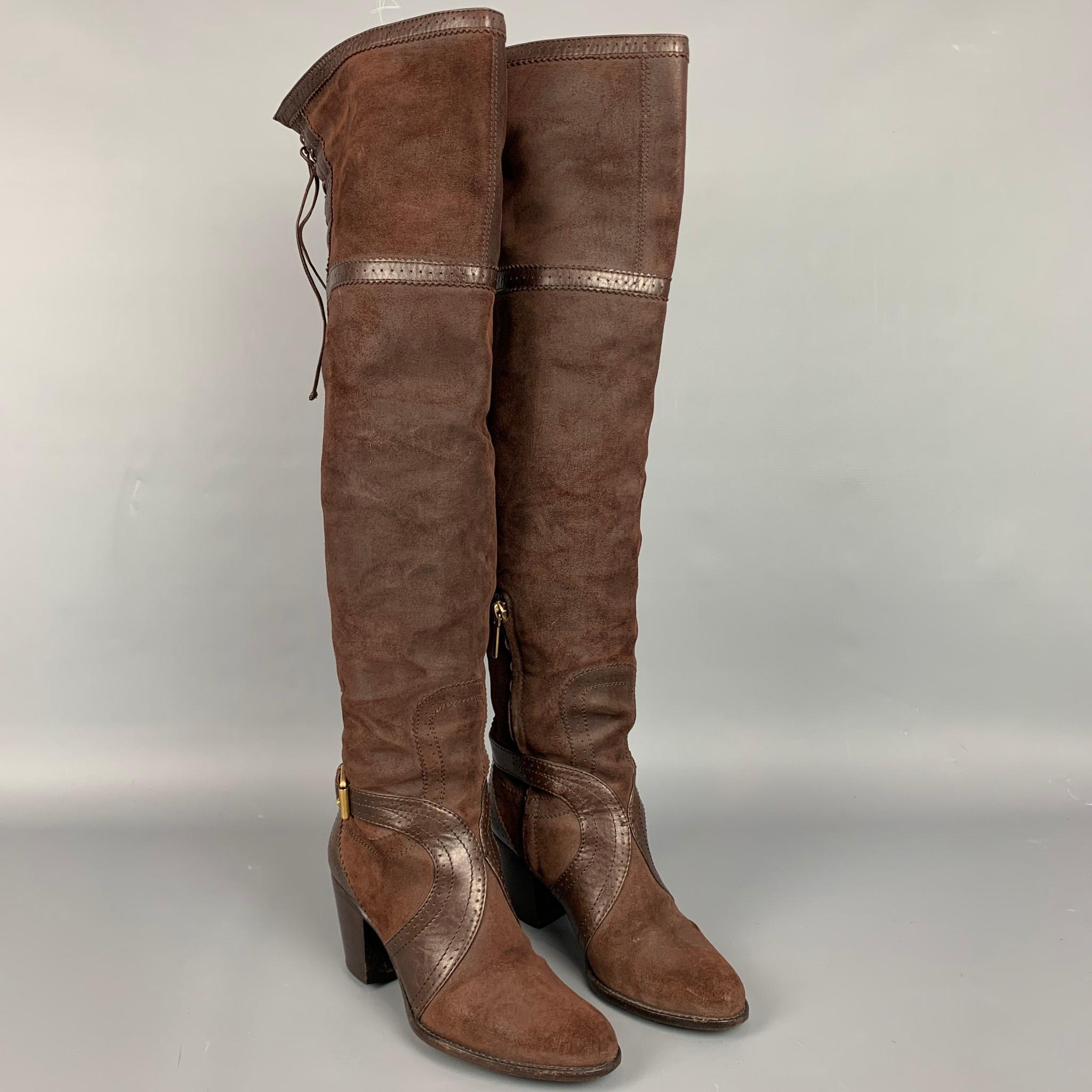 DIOR boots comes in a brown suede with a leather trim featuring a pirate style, buckle strap closure, and a chucky heel. Made in Italy.

Good Pre-Owned Condition.
Marked: IT 36

Measurements:

Length: 8.5 in.
Width: 3 in.
Height: 21 in. 