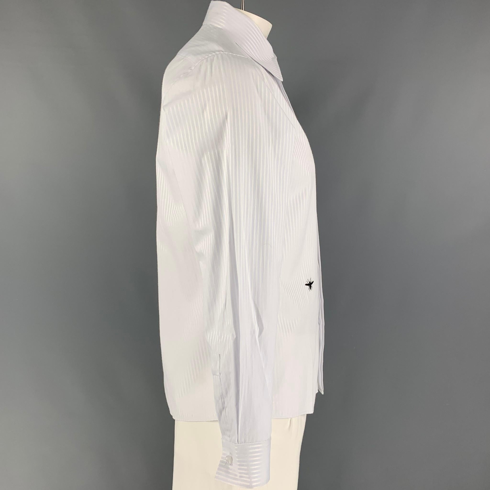 DIOR long sleeve shirt comes in a white & light blue stripe material featuring a spread collar, embroidered bee, and a hidden placket closure. Made in Italy. 

Very Good Pre-Owned Condition.
Marked: XL
Original Retail Price: