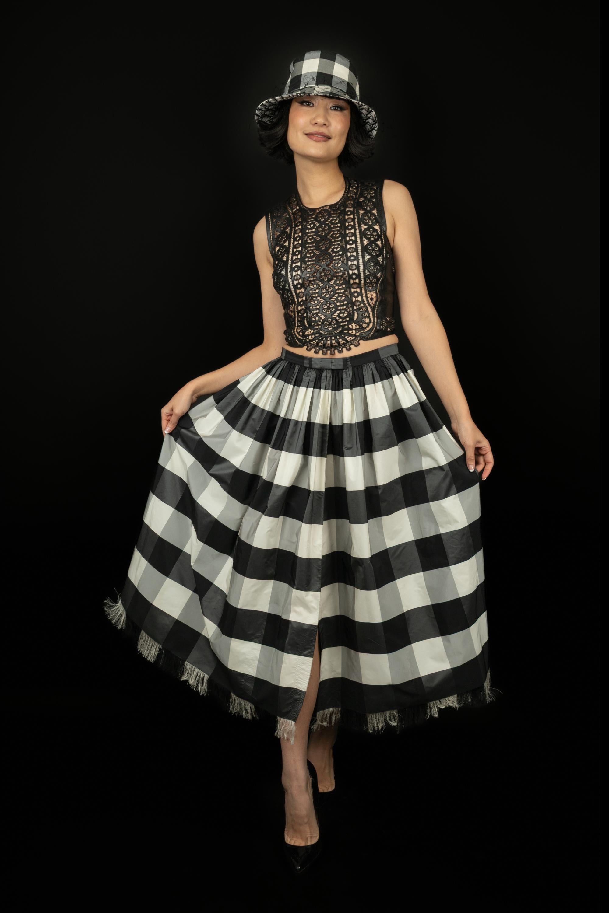 DIOR - (Fabriqué en Italie) Jupe en taffetas à carreaux noirs et blancs. Sans doublure. Taille 40FR. Collectional automne-hiver 2019 sous la direction artistique de Maria Grazia Chiuri.

Condit :
Très bon état.

Dimensions :
Taille : 34 cm -