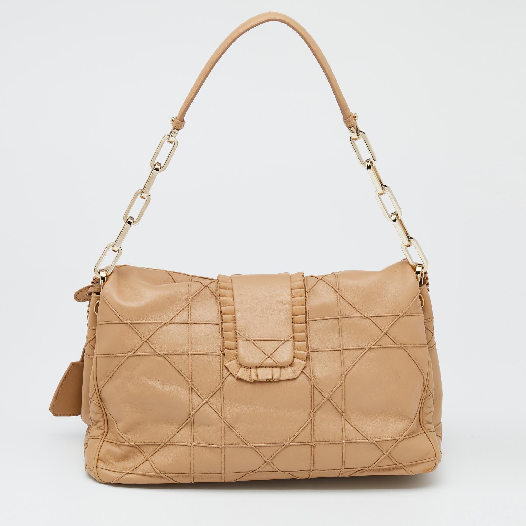 This Dior flap bag is named after 'New Look' — a term coined by Christian Dior himself. Covered in a gorgeous tan shade, the bag is crafted from leather and added with the Cannage motif and ruffle trims. A shoulder handle and a nylon interior